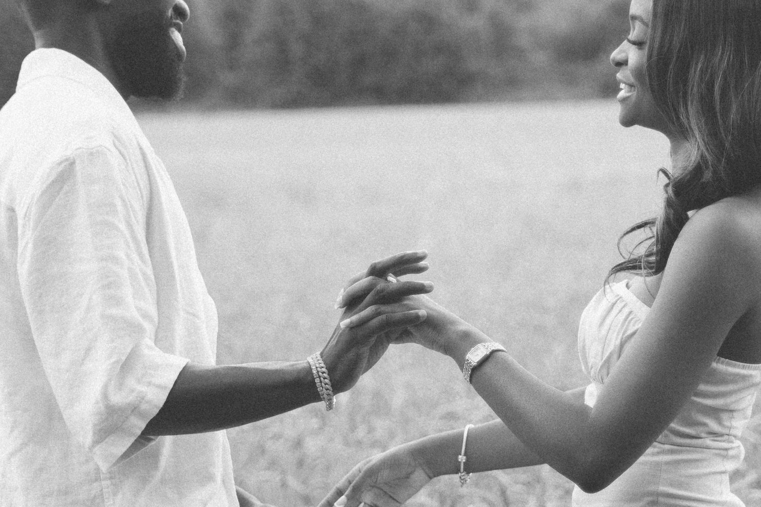 Couple engaged in animated conversation while standing in a sunny field.