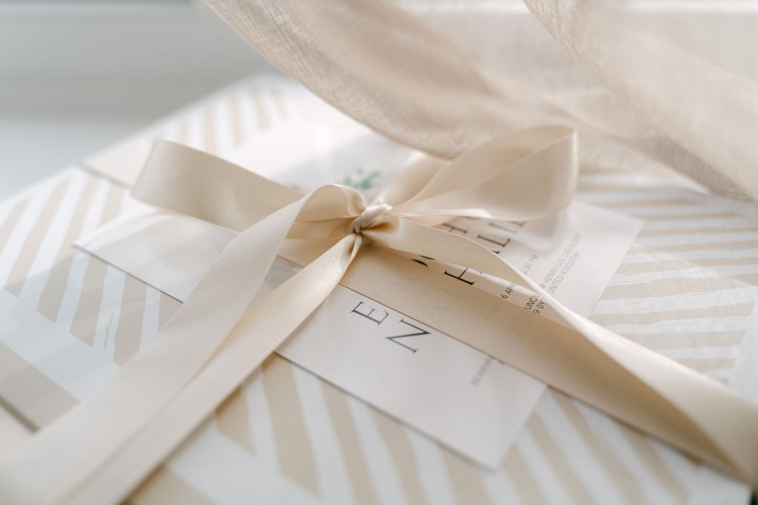 Wedding invitation suite in cream and white with delicate ribbon details.