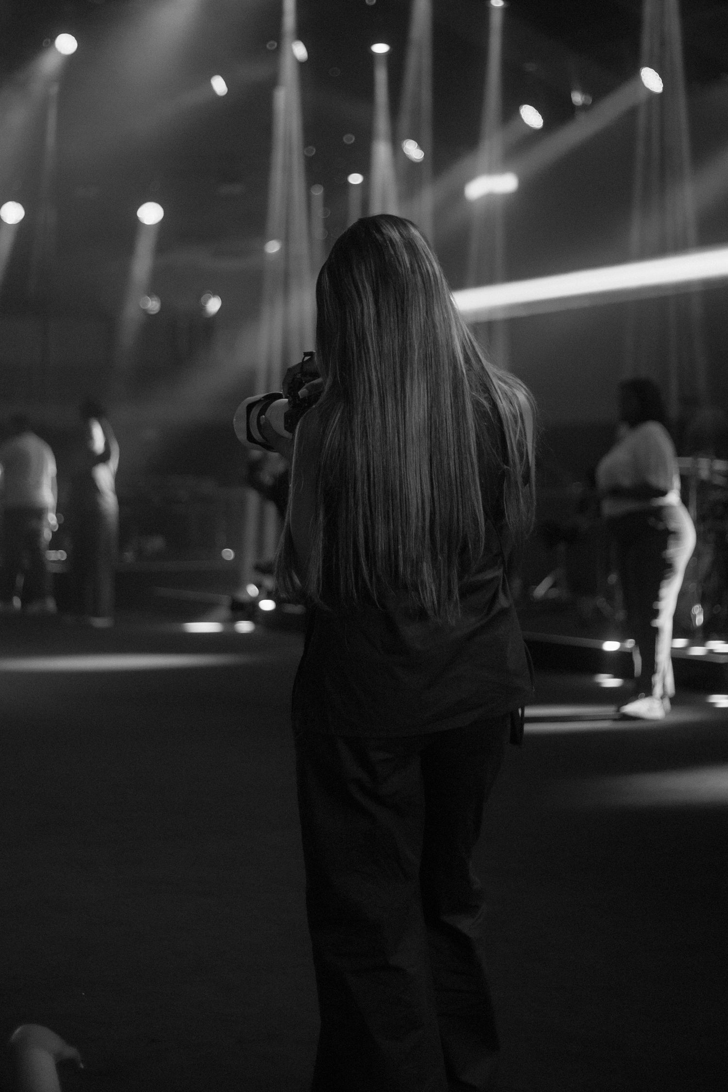 Silhouetted figures dance at a dimly lit nightclub with bokeh lights in the background.