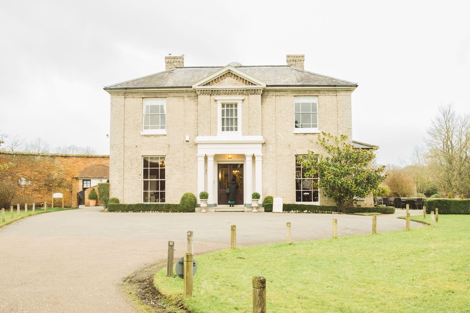 Elegant cream-colored Georgian style mansion with symmetrical windows and grand entrance.