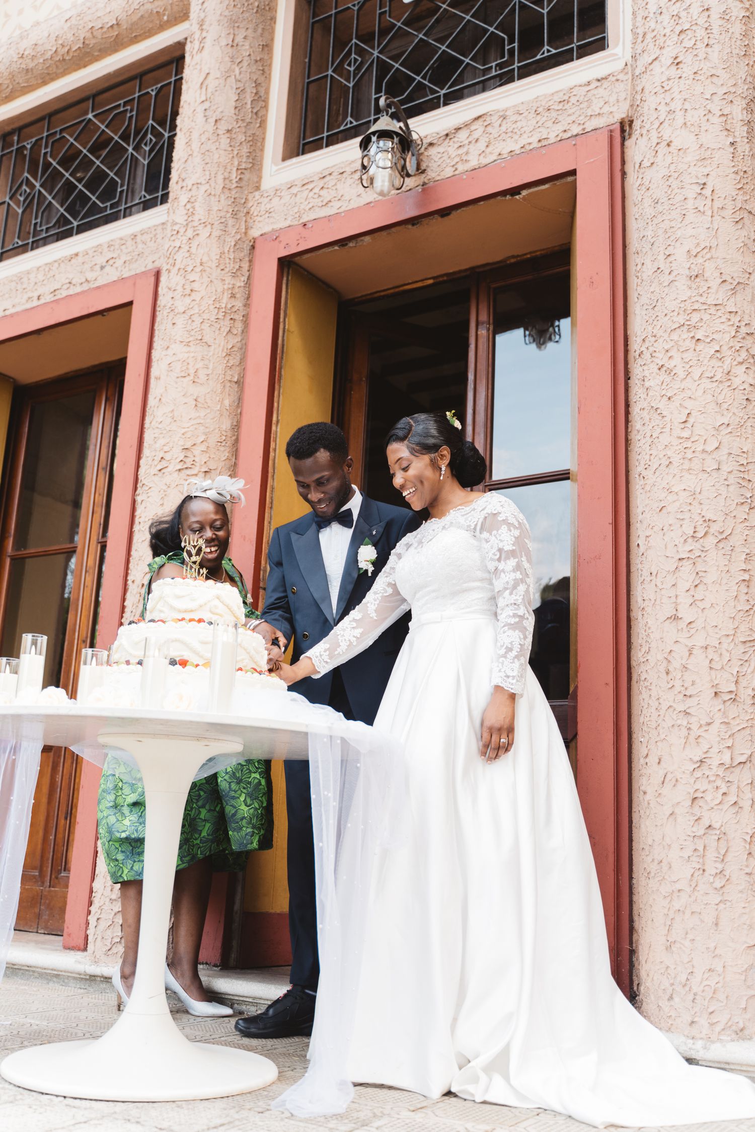 Wedding party gathered on stone steps outside historic building entrance.