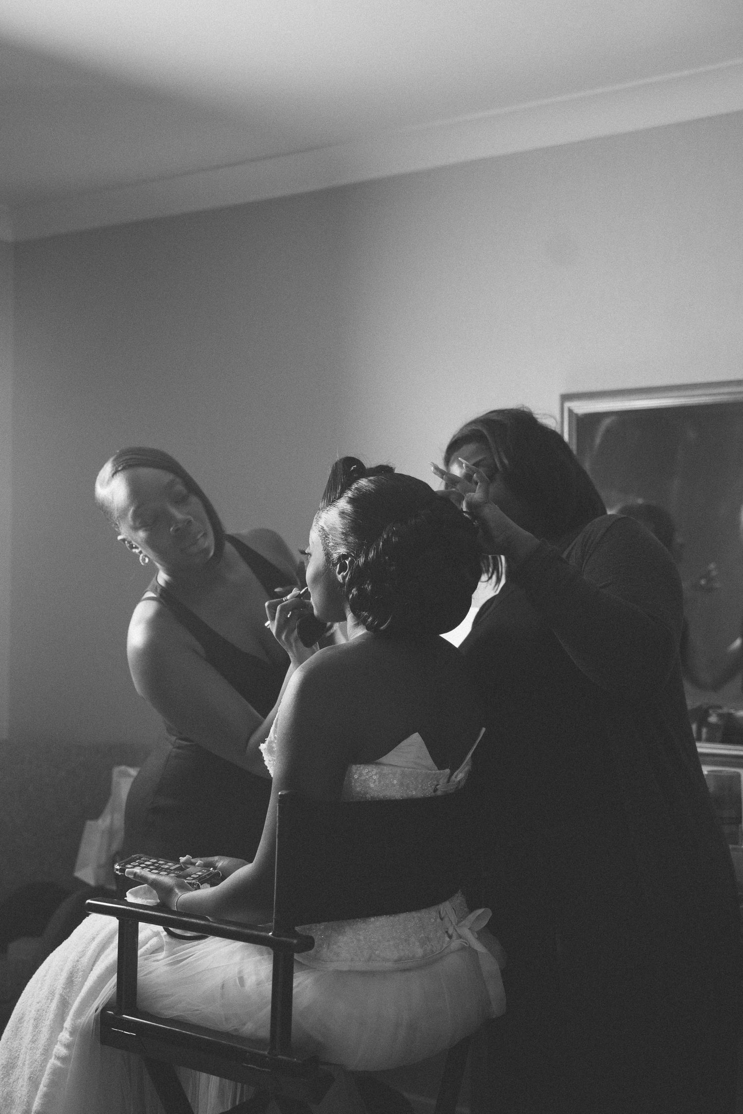 A group of people lean back in unison during a performance in a dark room.