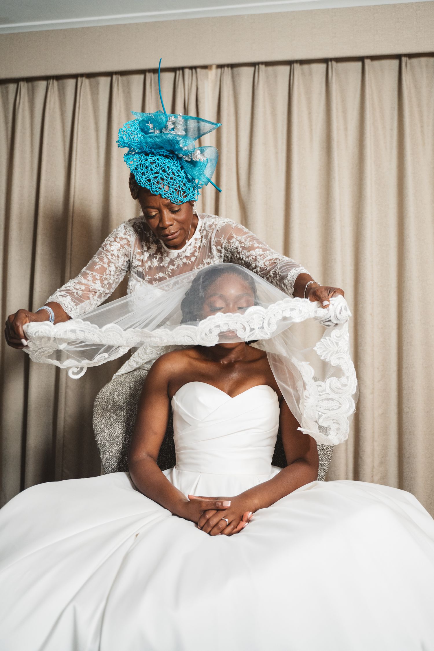A white wedding gown with delicate lace details and turquoise headpiece.