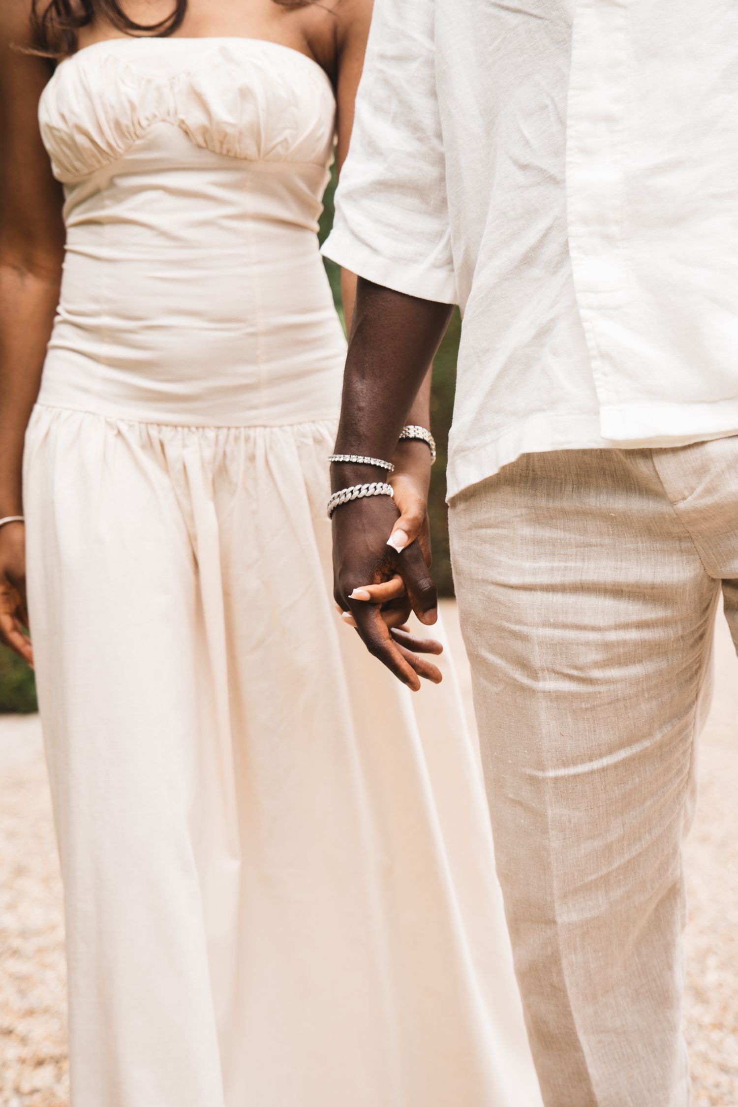 People wearing coordinated white and cream formal attire shown from waist down.
