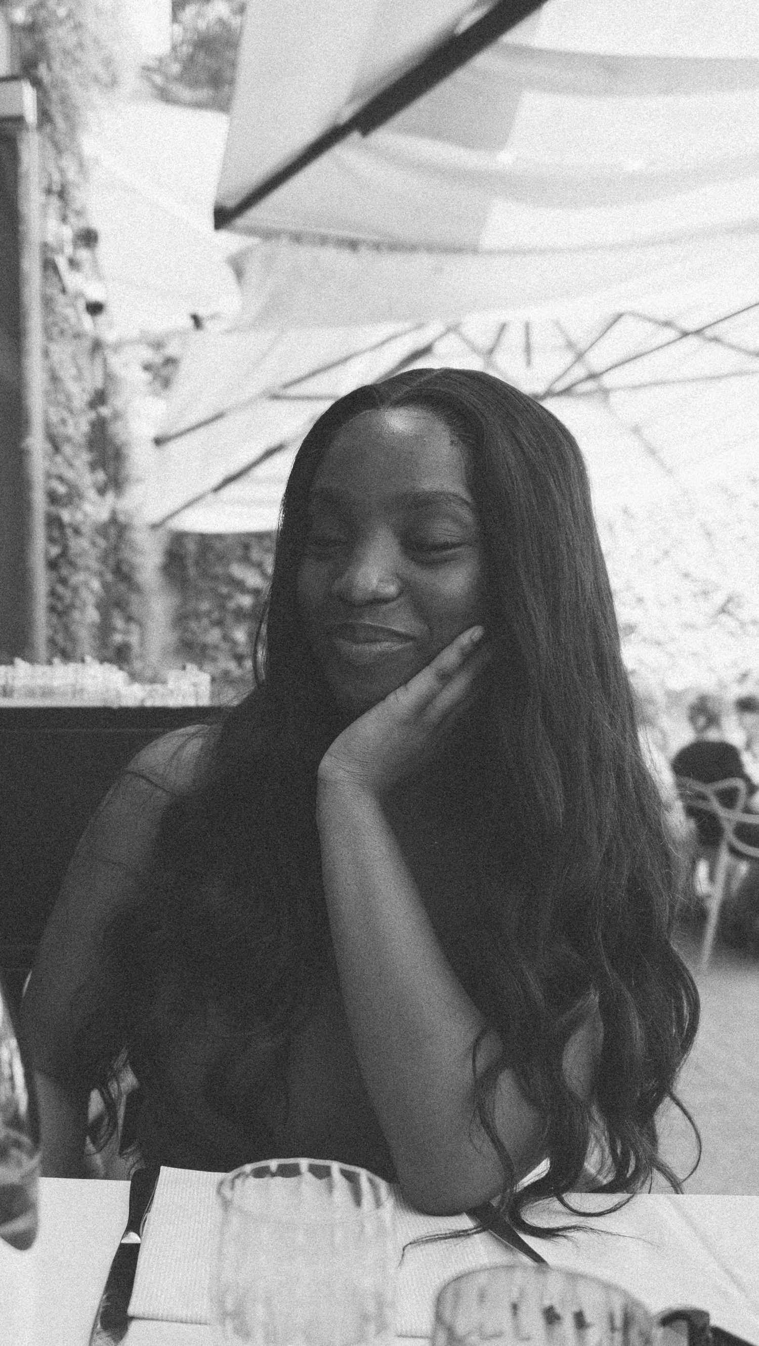 Black and white portraits capture joyful laughter moments at an outdoor restaurant setting.
