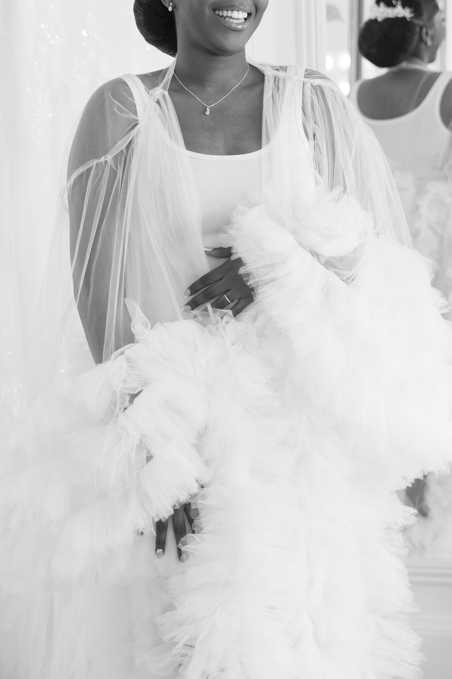 A dreamy white wedding dress creates an ethereal effect in bright lighting.