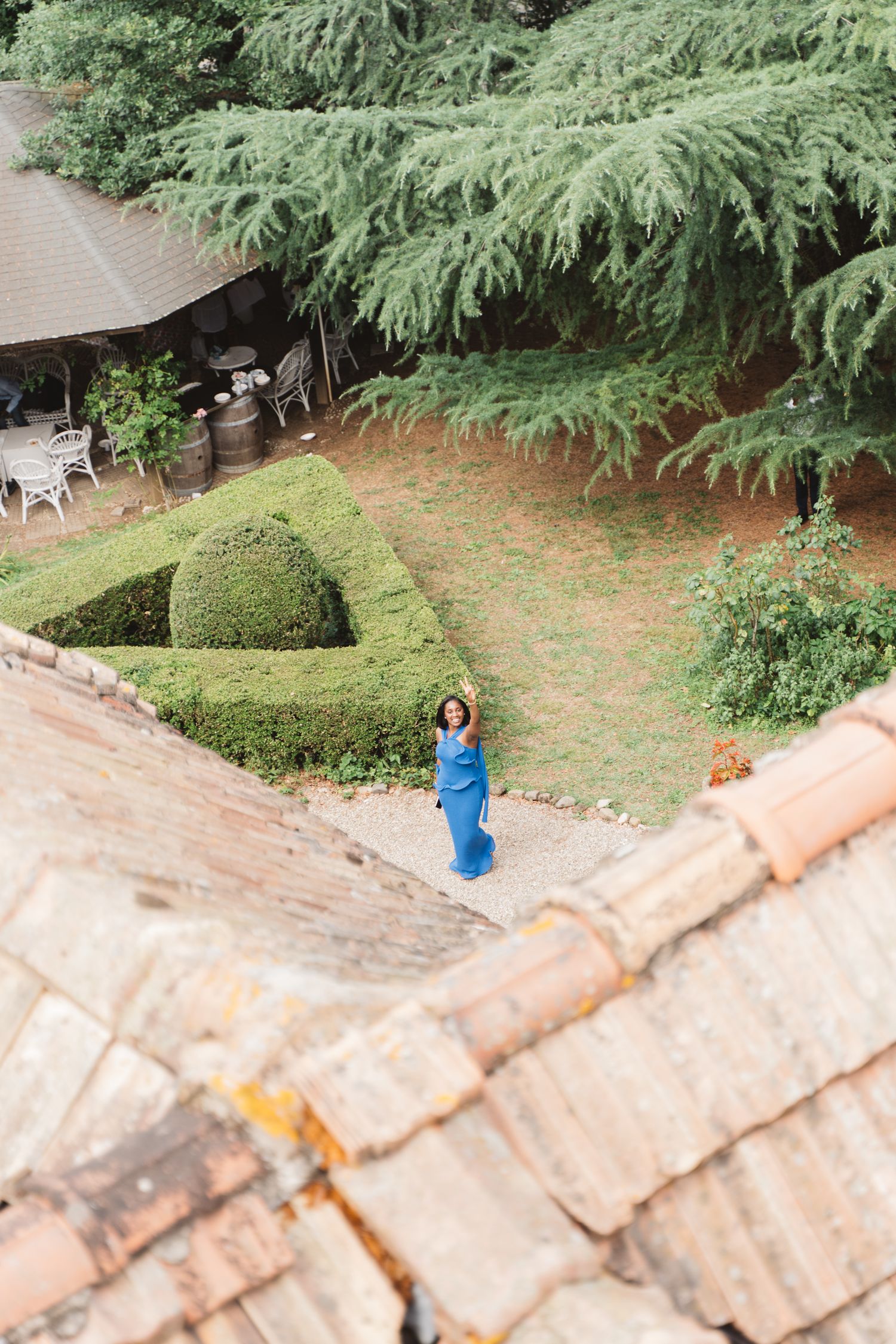 View from above of a manicured garden with hedges and a figure in blue.