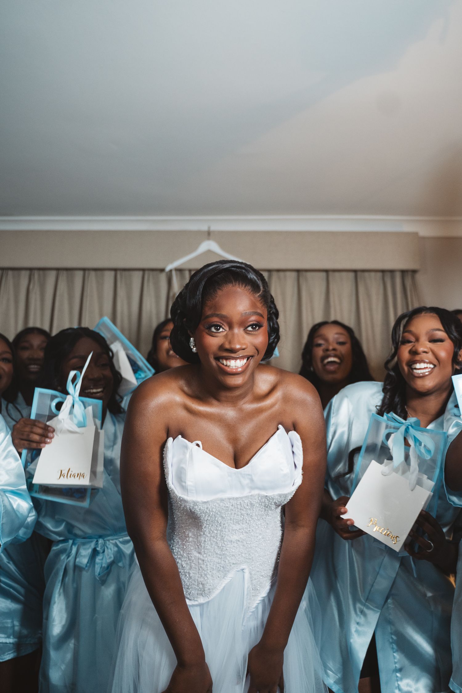 Bridesmaids in light blue dresses celebrate joyfully with the bride.