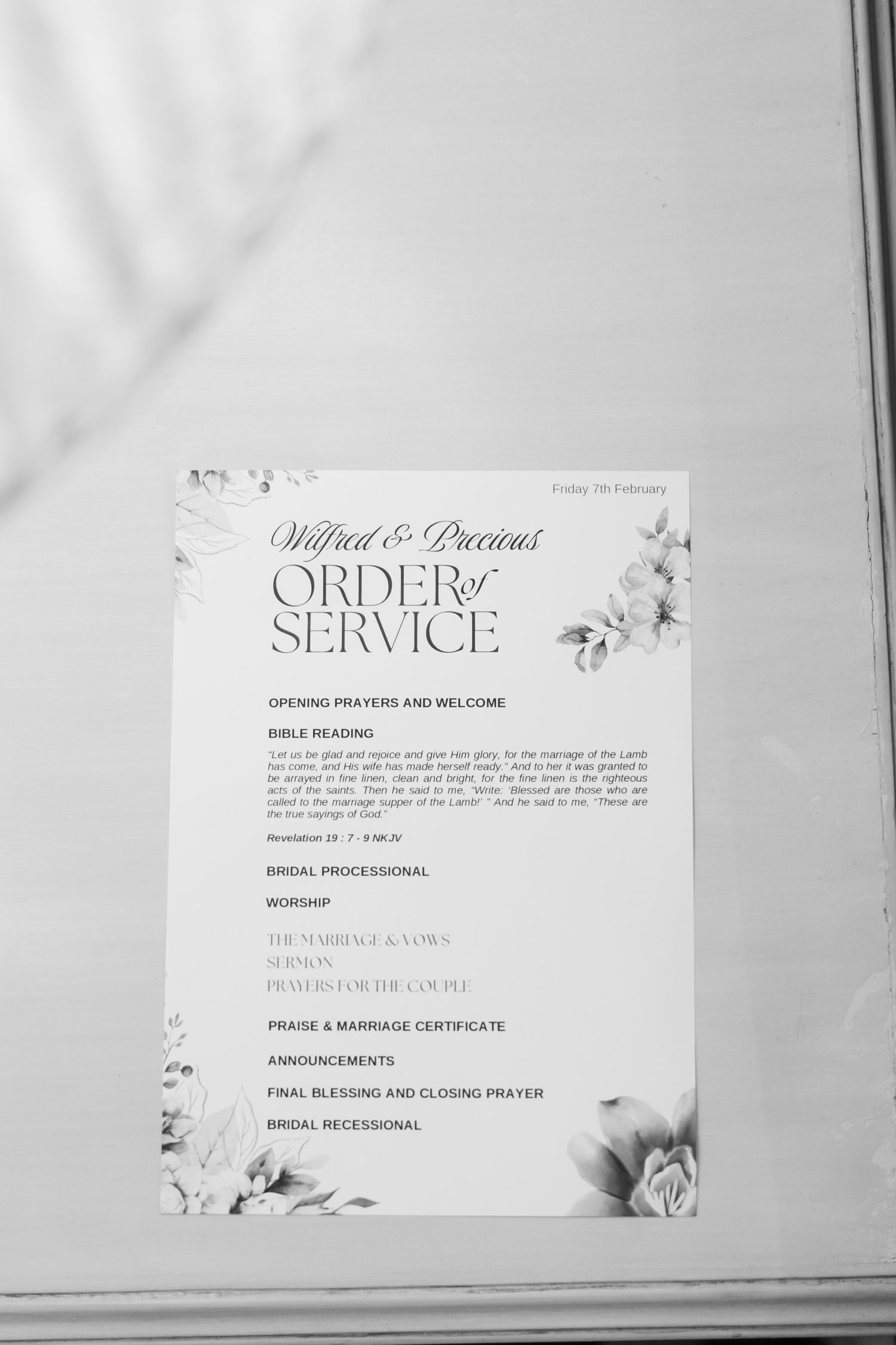 Black and white wedding order of service program with floral design elements.
