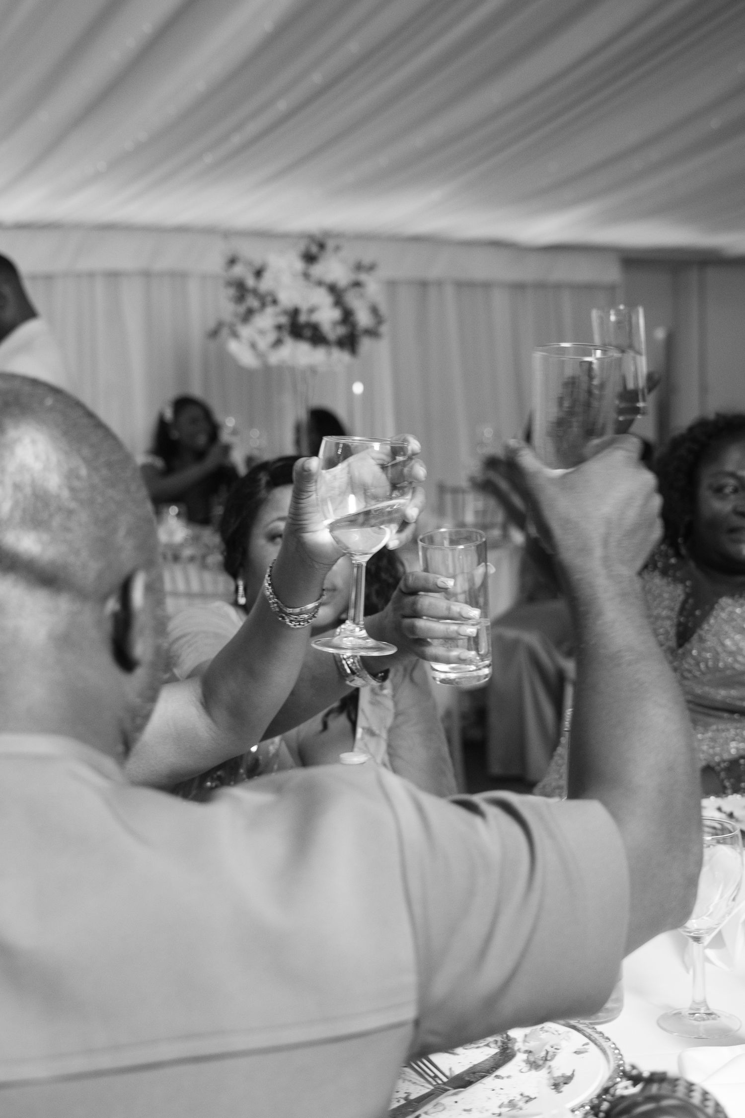 Wedding guests raise champagne glasses for a celebratory toast.