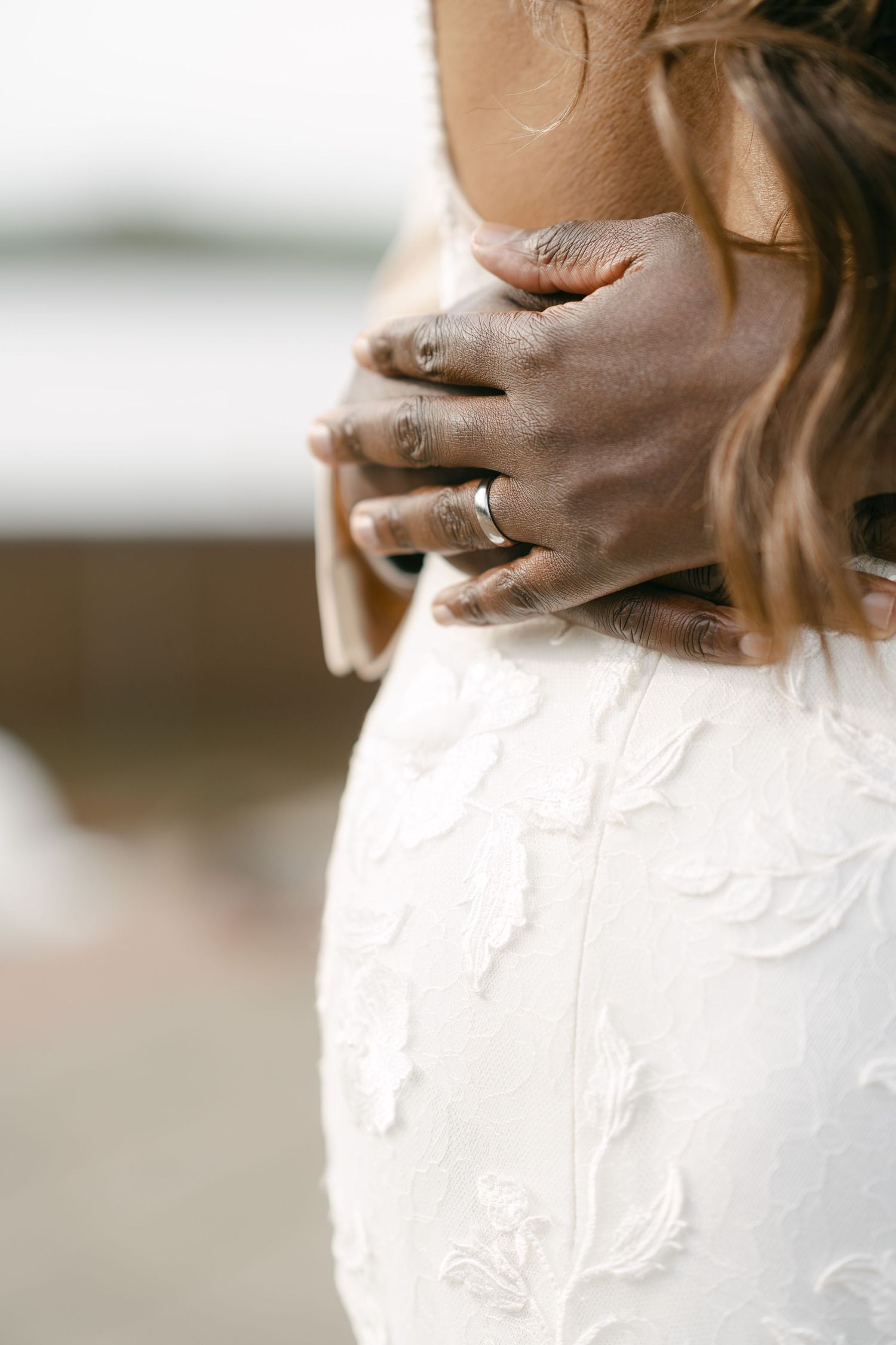 Close-up detail of delicate white lace pattern on a wedding dress.