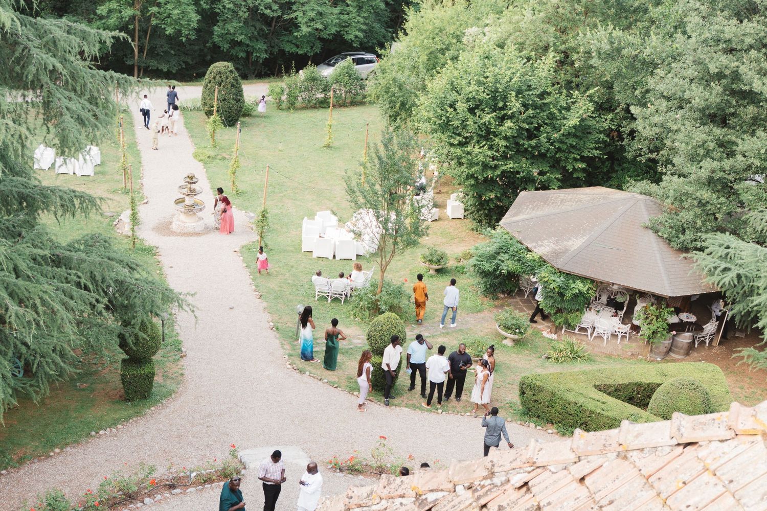 Aerial view of guests gathering on garden paths at an outdoor event venue.