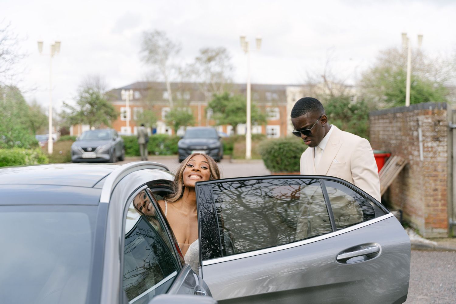Wedding couple shares a romantic moment near their car after the ceremony.