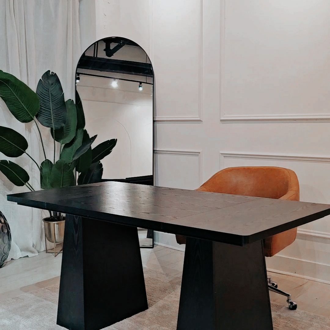 Black table with geometric bases arranged in a bright contemporary space.