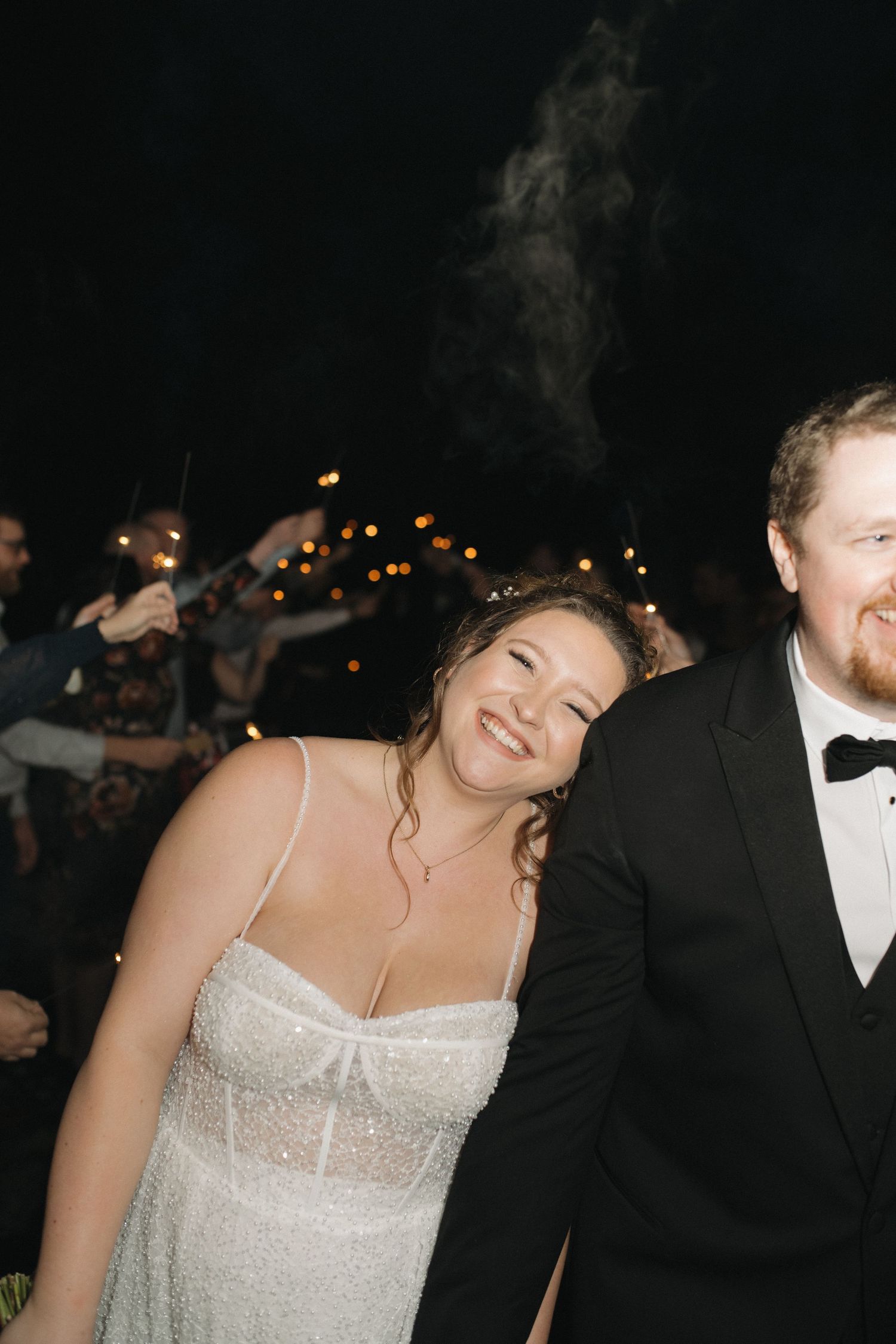 Couple in formal wedding attire dancing together at an evening reception.