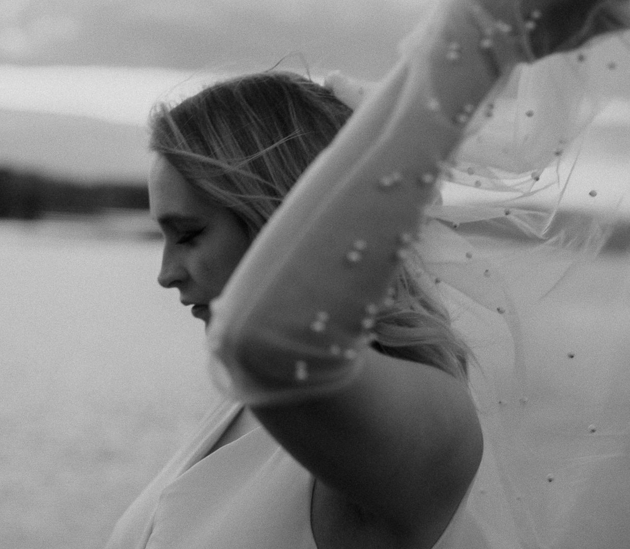 Artistic black and white portrait showing a side profile in motion with water droplets.