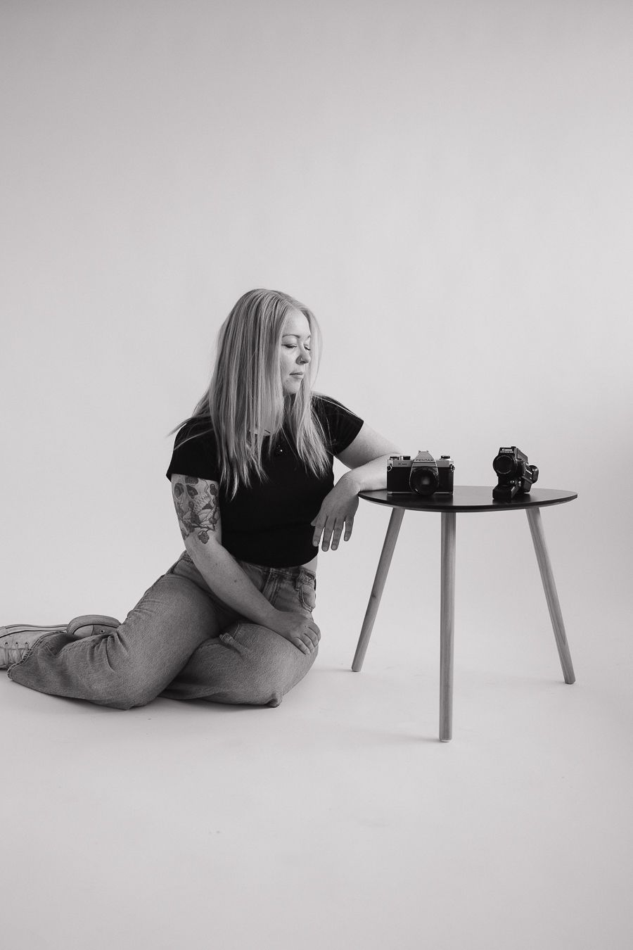 Series of minimalist black and white photos showing a photographer lying on floor with camera equipment.