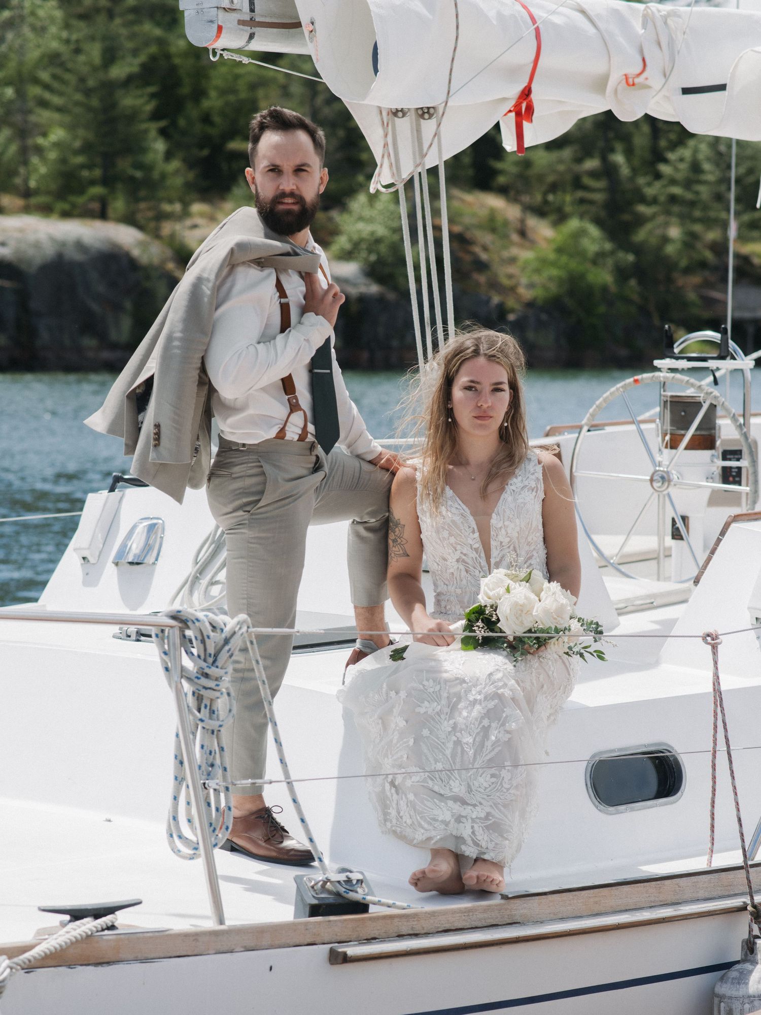 Wedding couple posing on sailboat during portrait session at Killarney Mountain Lodge in Killarney Ontario