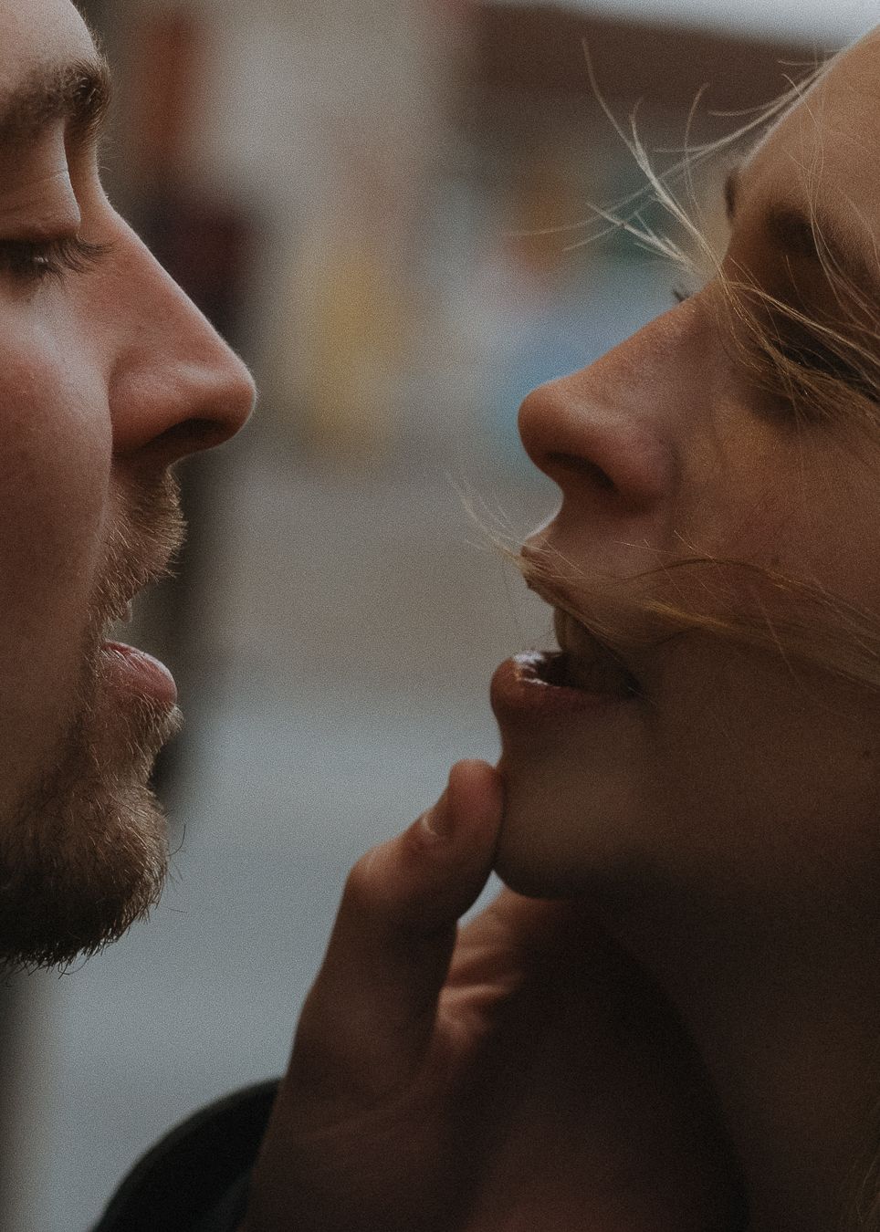 An intimate close-up portrait of two faces about to kiss.