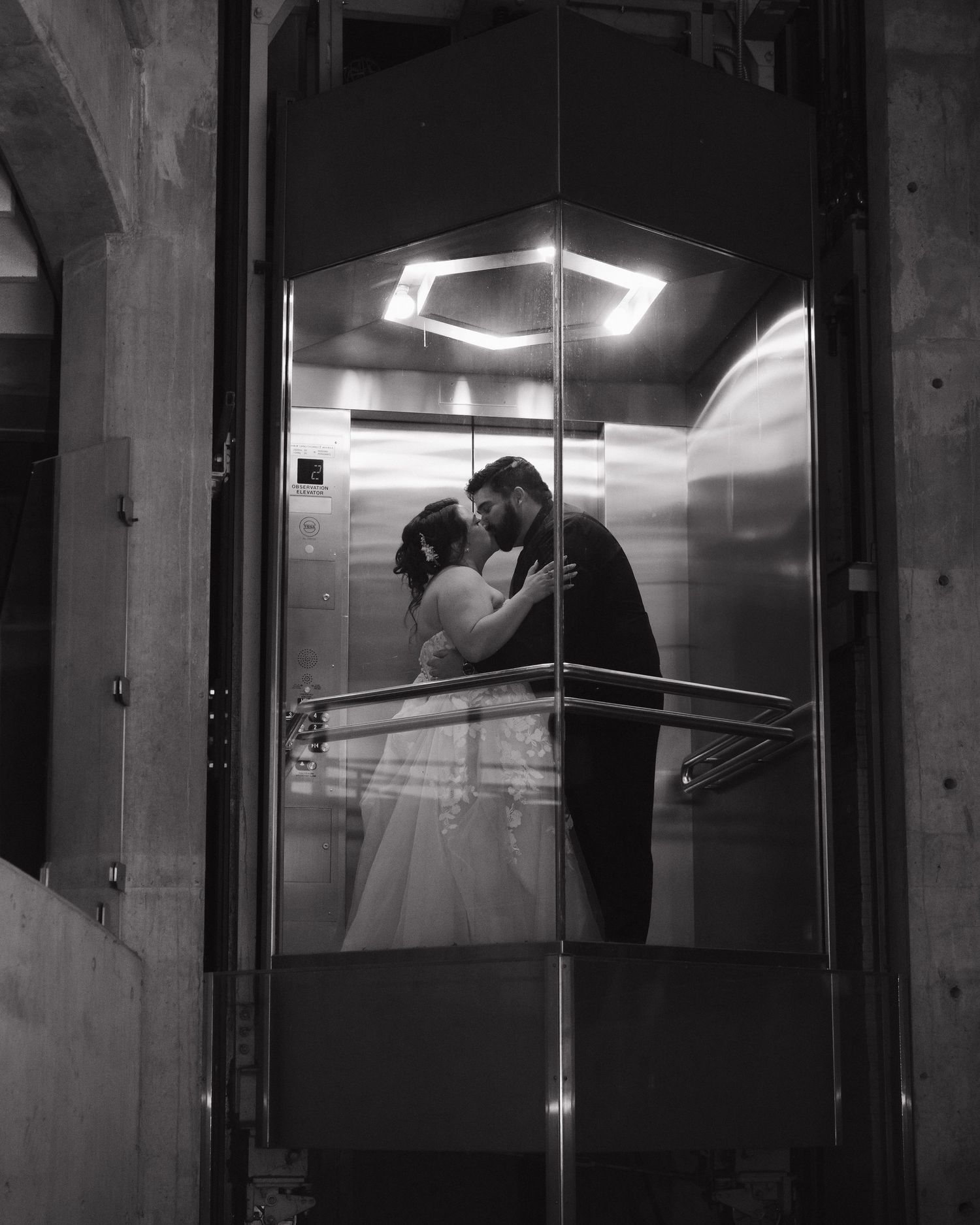 Black and white newlyweds sharing intimate moment in elevator at Science North wedding in Sudbury