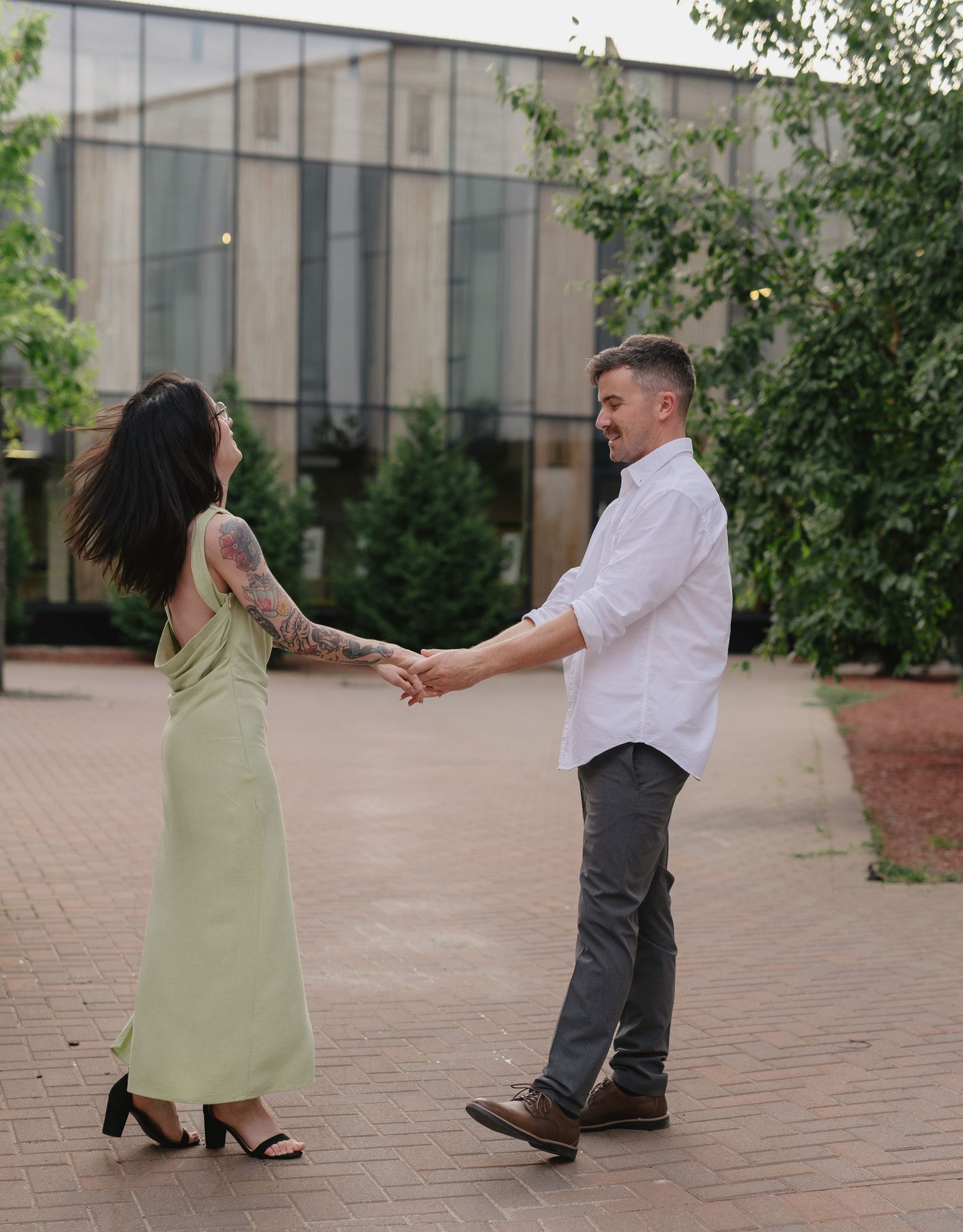 Romantic couple dancing together on brick courtyard Laurentian University McEwen School of Architecture downtown Sudbury.