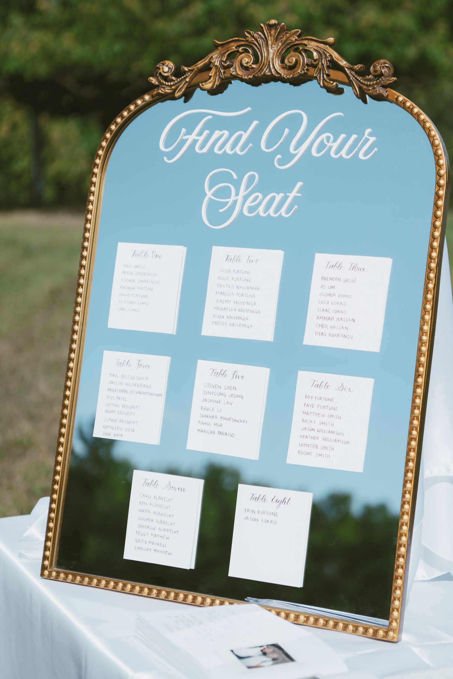 Gold ornate framed mirror seating chart displaying 
