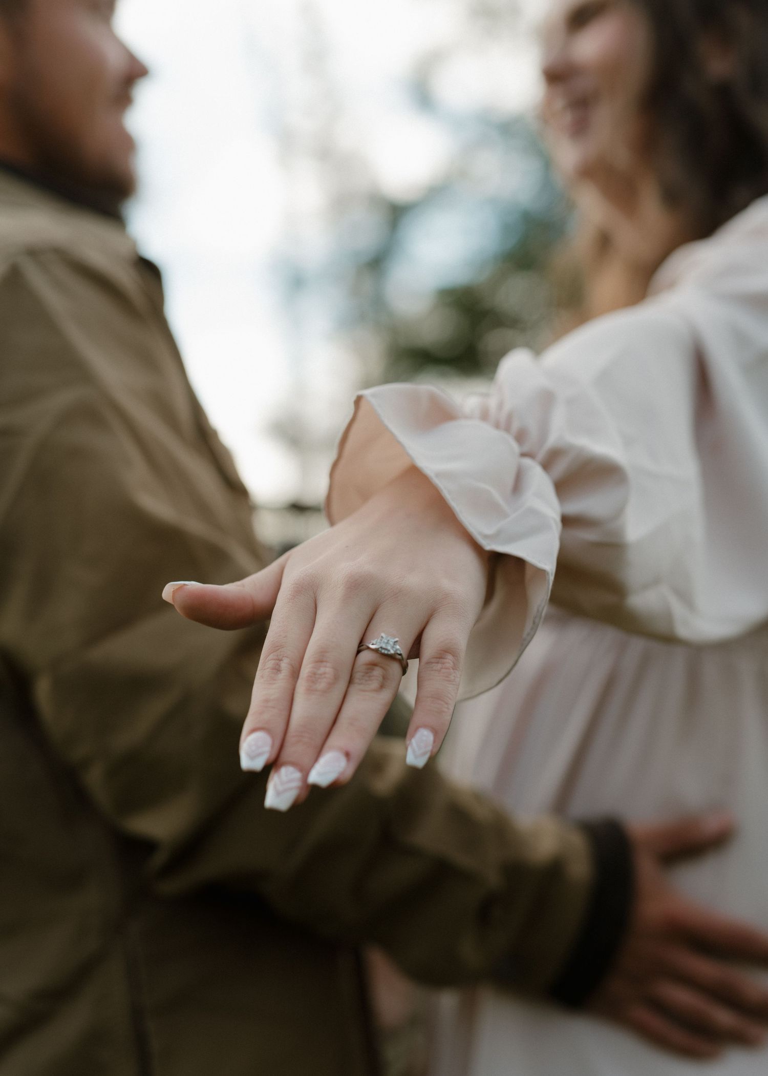 A close-up sequence showing hands with an engagement ring in multiple romantic poses against a blurred background.