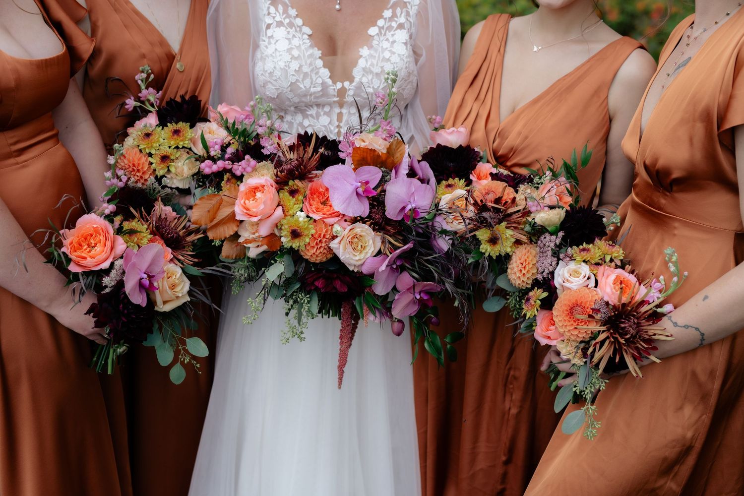 Wedding party bouquets featuring colorful flowers in coral and purple tones.