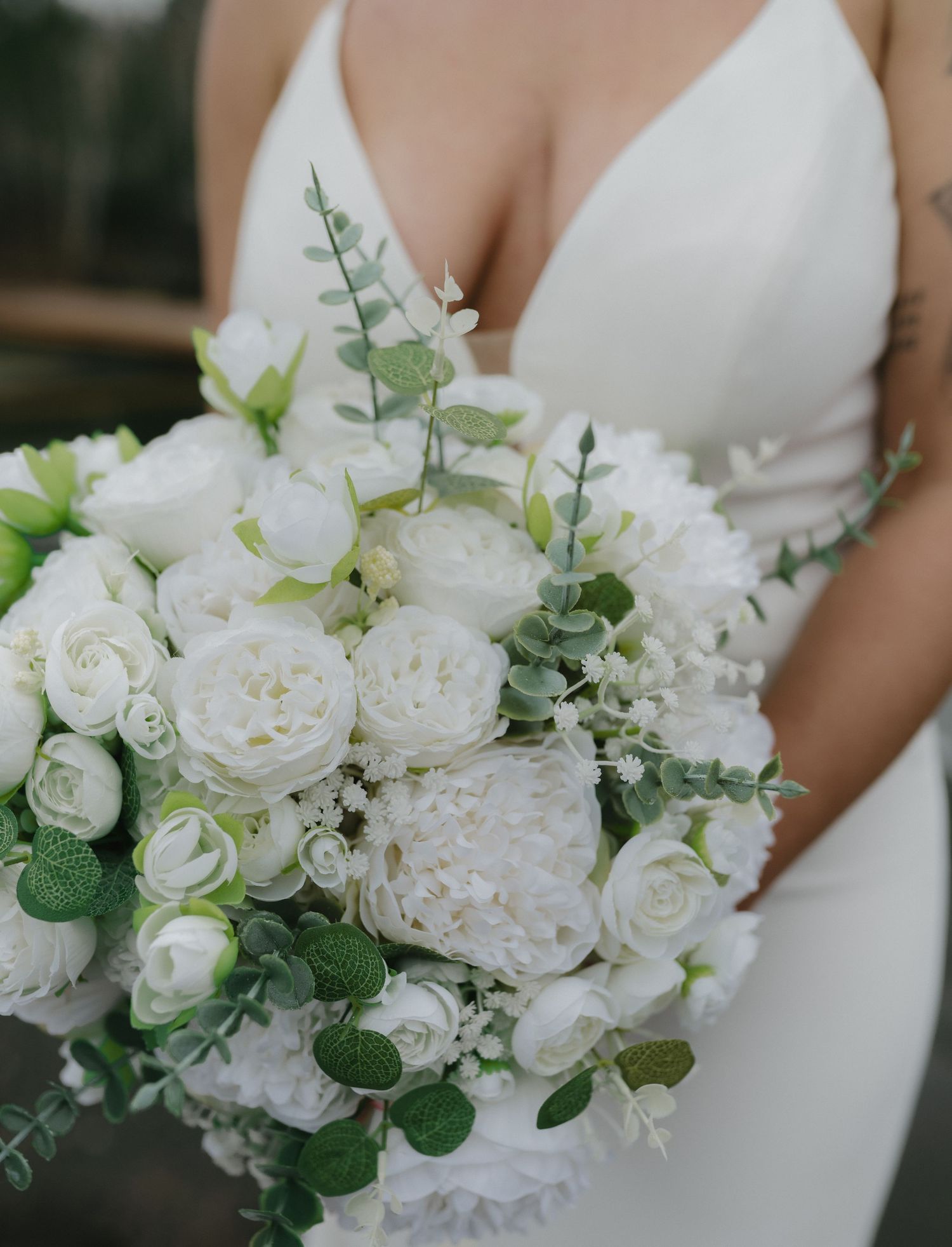 Stunning white bridal bouquet featuring roses, hydrangeas and eucalyptus leaves.
