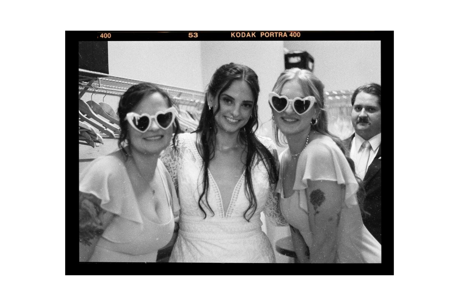 A series of black and white photo booth style snapshots showing friends posing and smiling together.