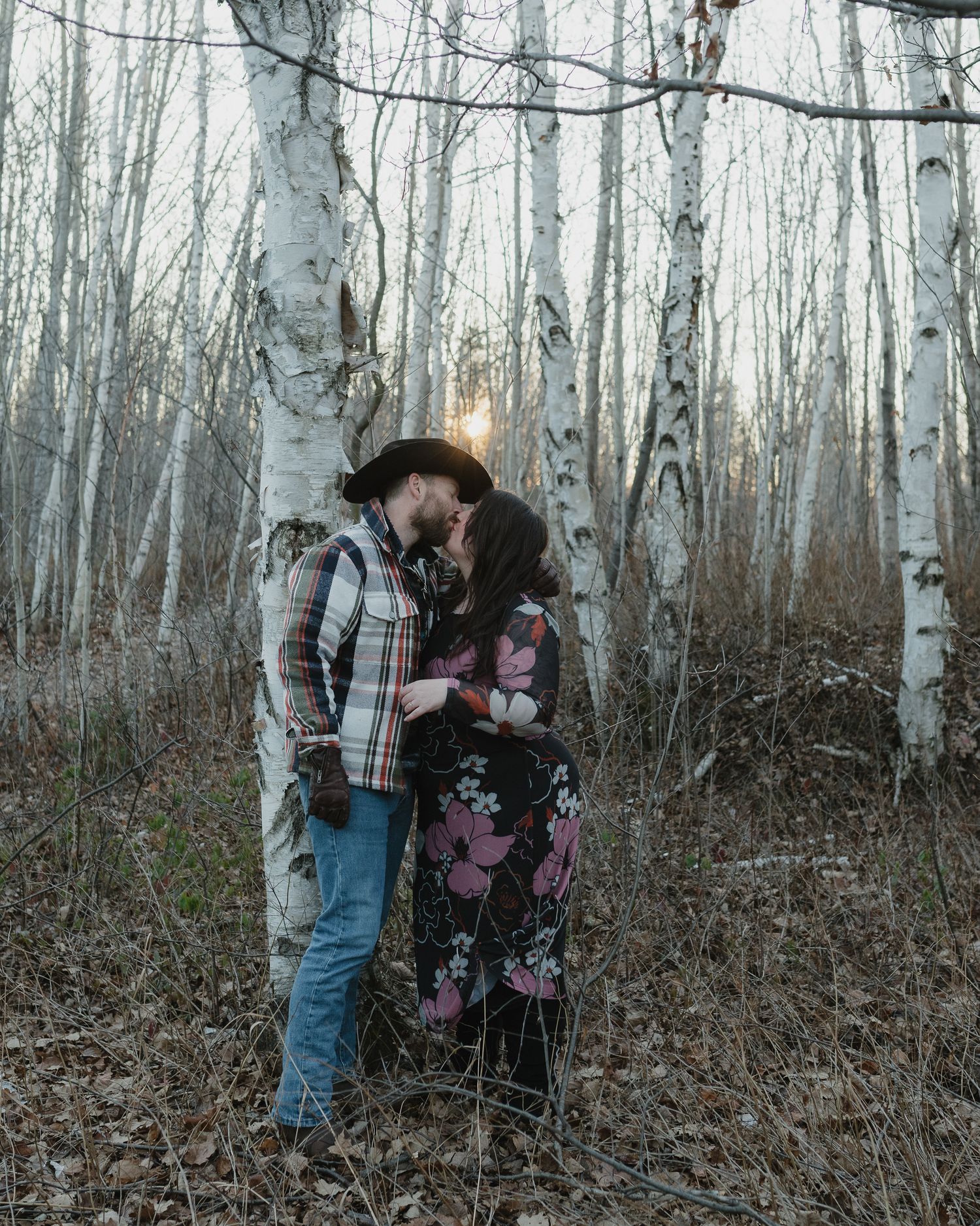 A couple embraces in a misty birch forest during a romantic winter photoshoot.