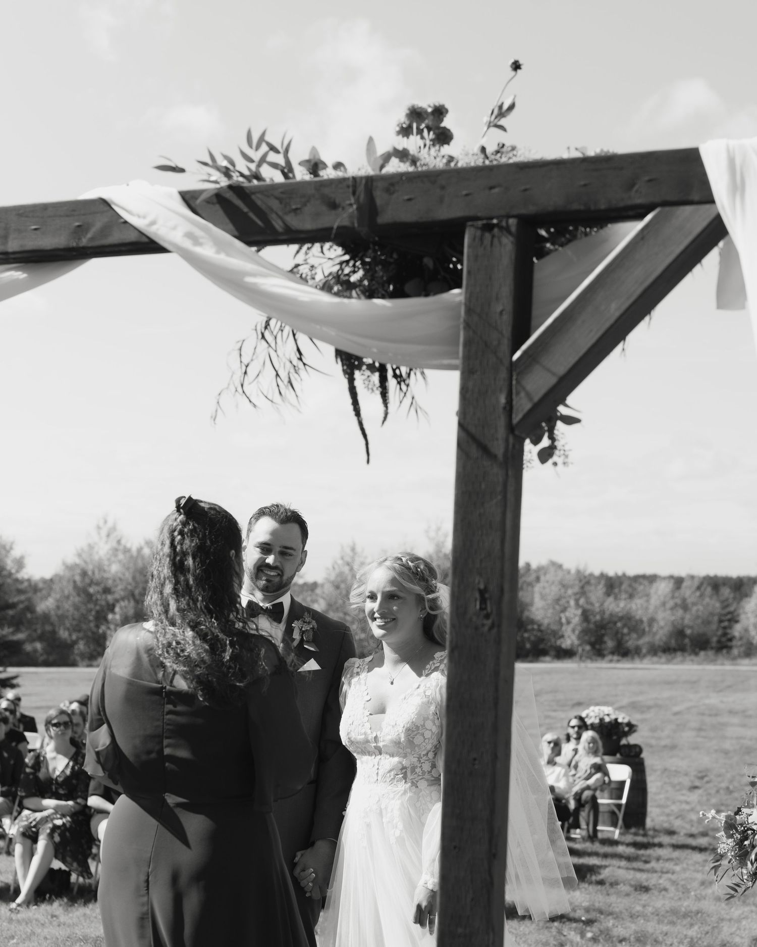 A black and white photo series showing an outdoor wedding ceremony under a rustic wooden pergola.