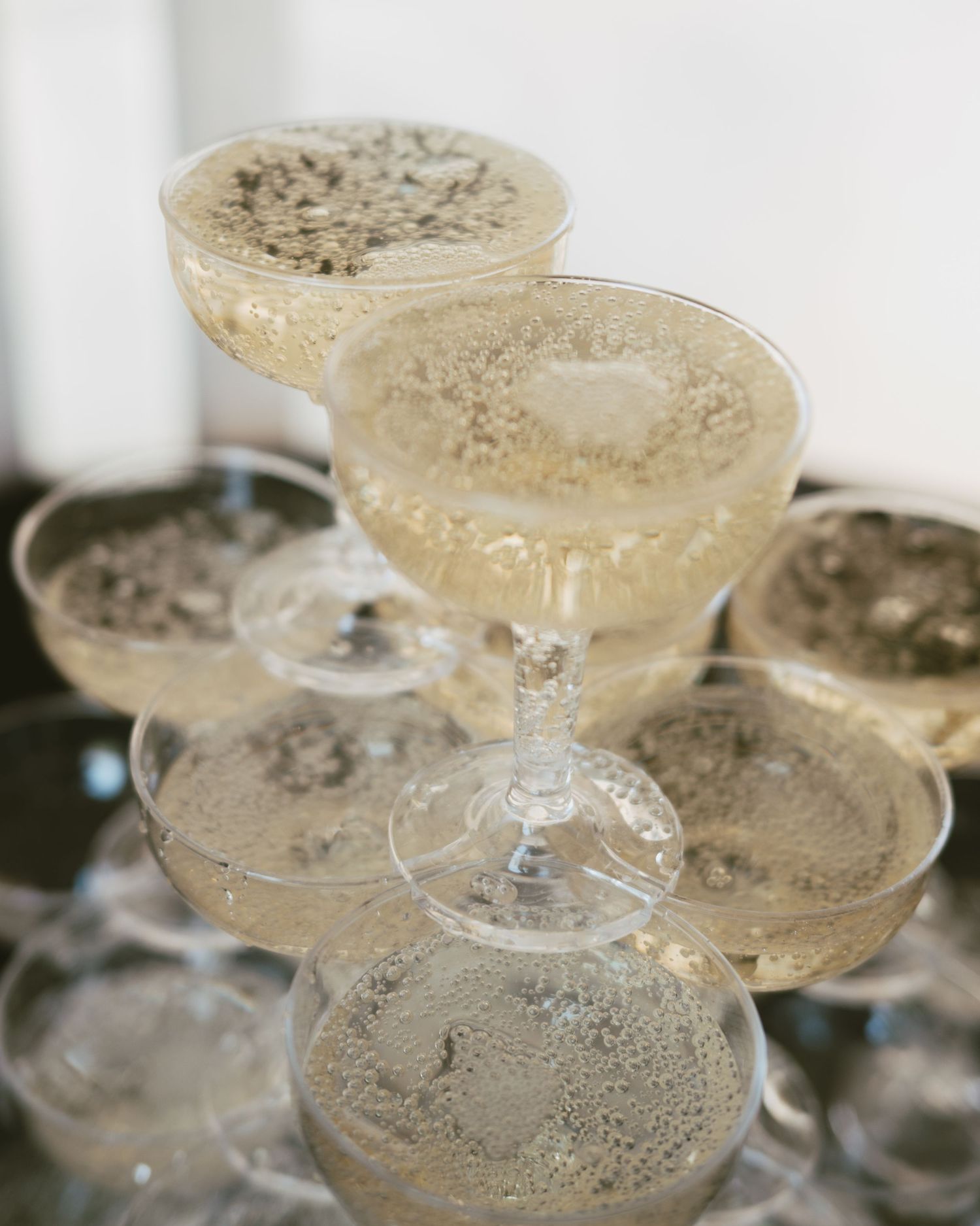 Elegant champagne tower with sparkling wine in coupe glasses, perfect for weddings and celebrations.
