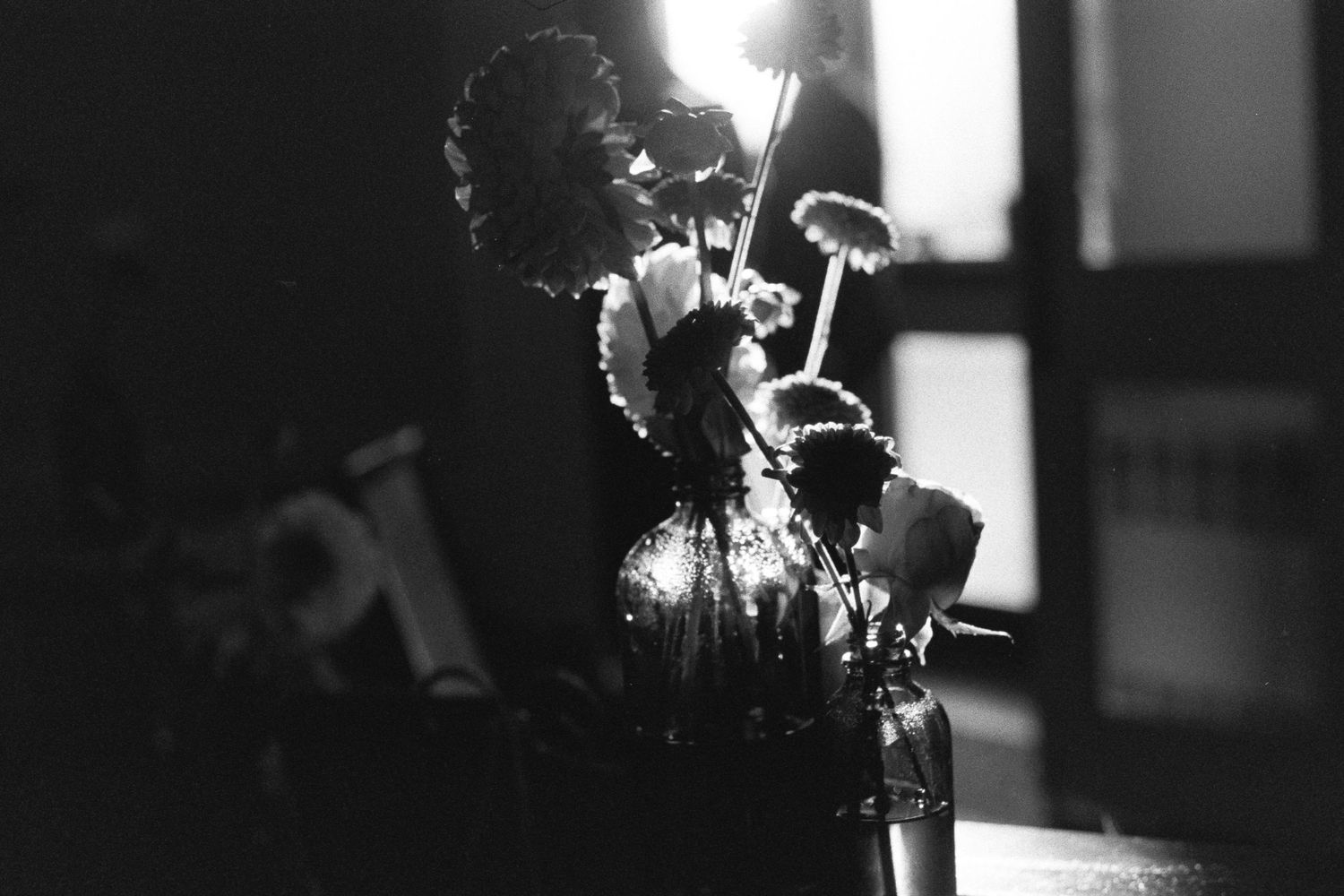 Dramatic black and white lighting creates moody silhouettes in a studio setting.