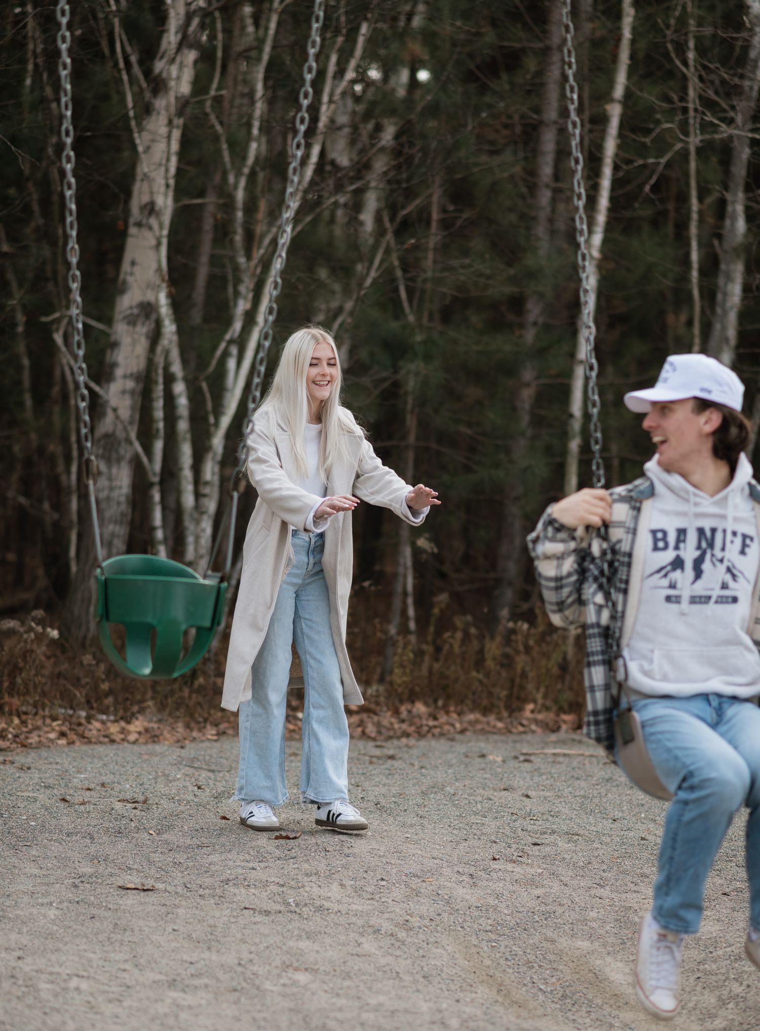 A playful sequence shows someone in jeans and a sweatshirt jumping and dancing in front of a wooded area.