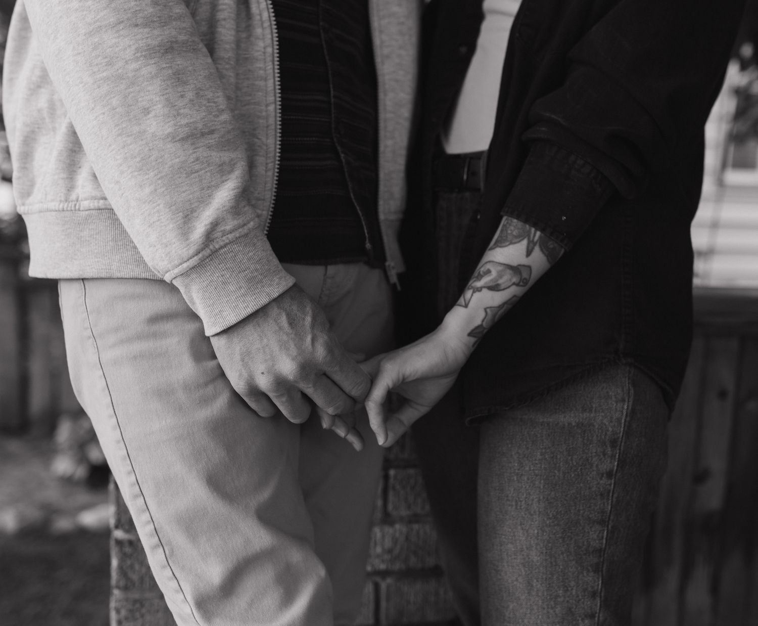 Close-up view of hands holding a pair of dark blue denim jeans with visible stitching details.