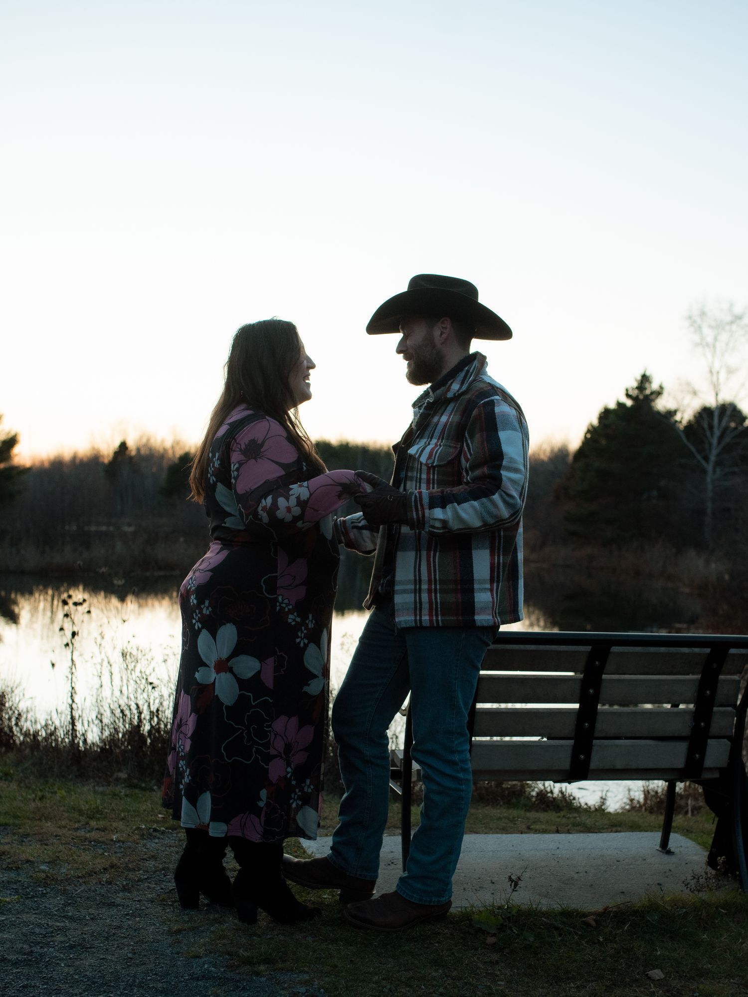 A couple in western attire shares an intimate moment at sunset by a serene lake with multiple similar views.