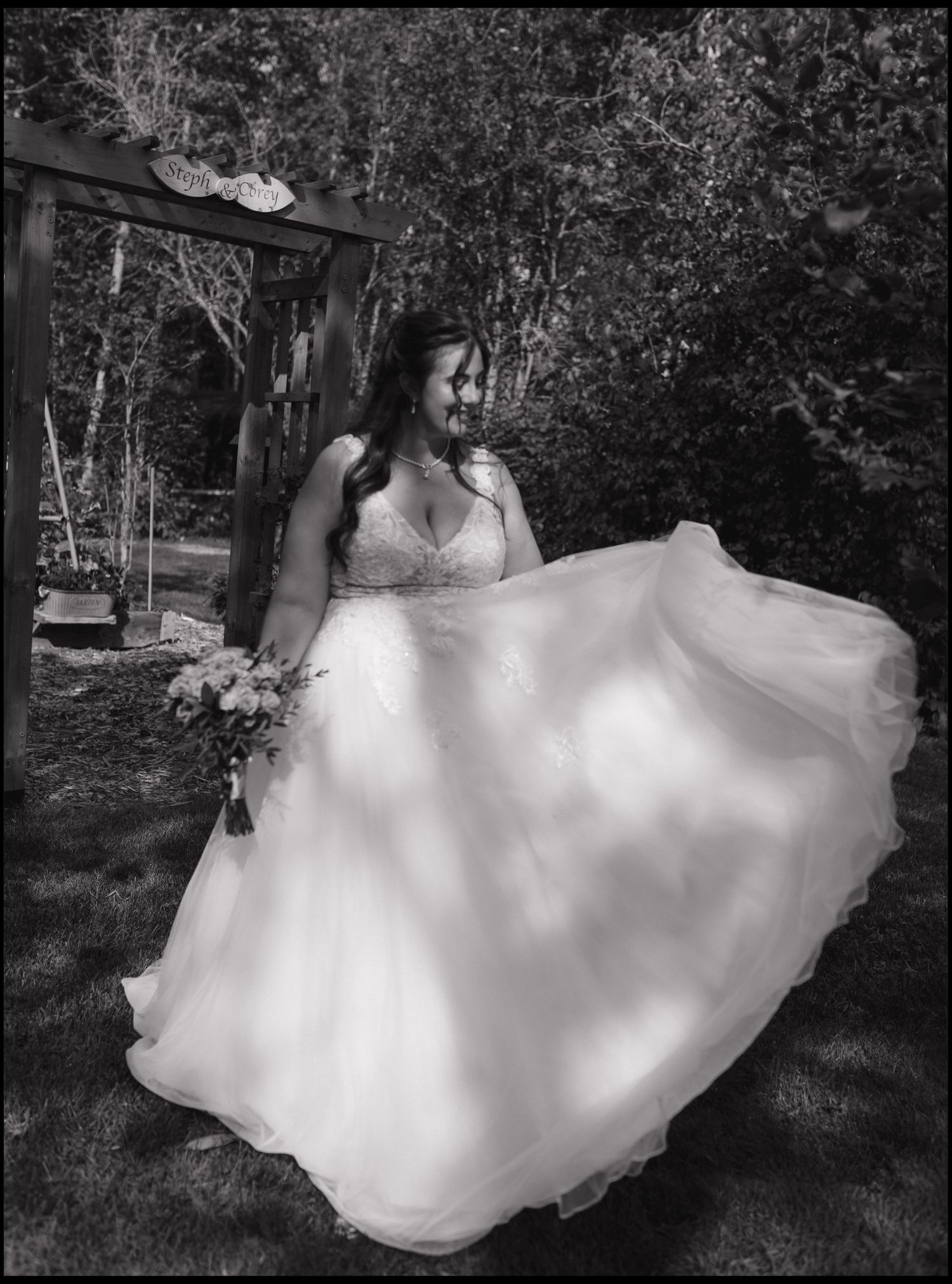 A flowing white wedding dress twirls gracefully in a series of black and white photographs taken outdoors among trees.