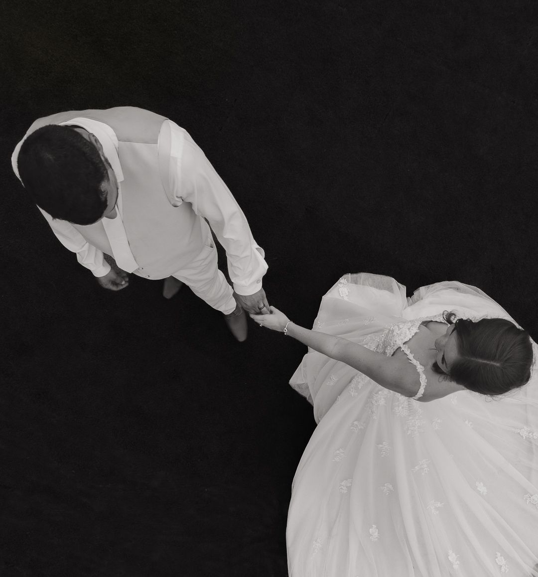 Black and white artistic photo of two dancers in flowing white outfits performing a dramatic dip.
