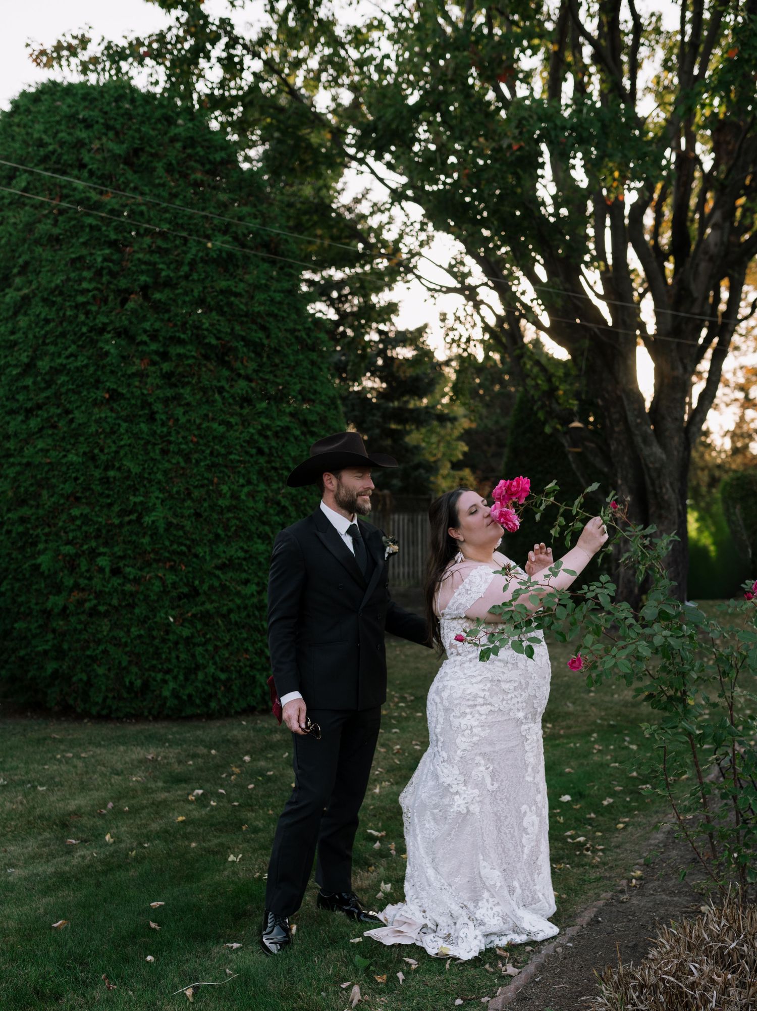 A couple shares joyful moments in a lush garden setting during golden hour.