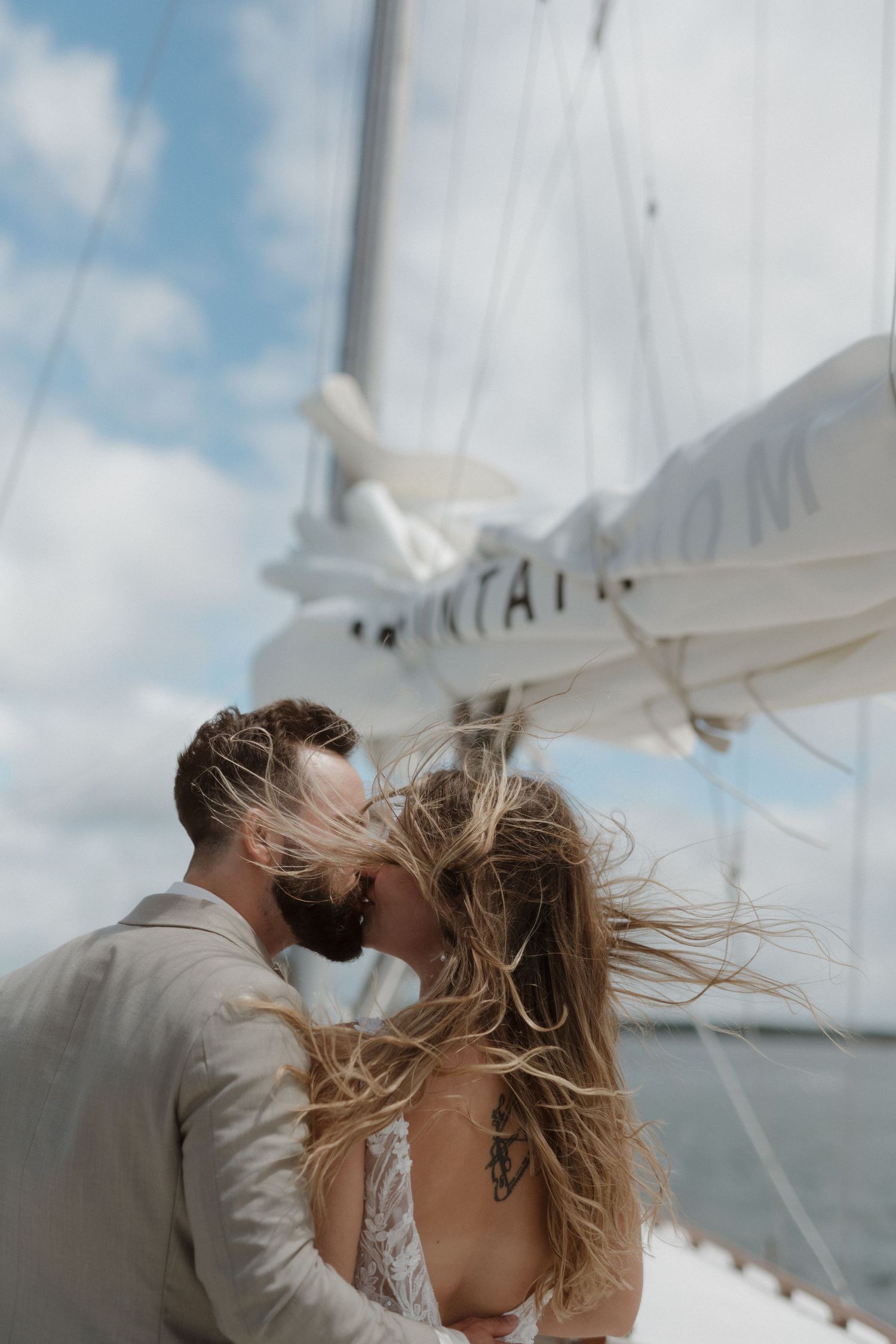 Bride and groom kissing under sail aboard Killarney Mountain Lodge Sailboat Tours in Ontario