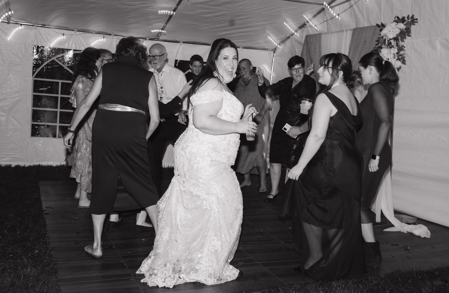 Intimate backyard editorial wedding reception scene with bride dancing with guests in Sudbury Ontario.