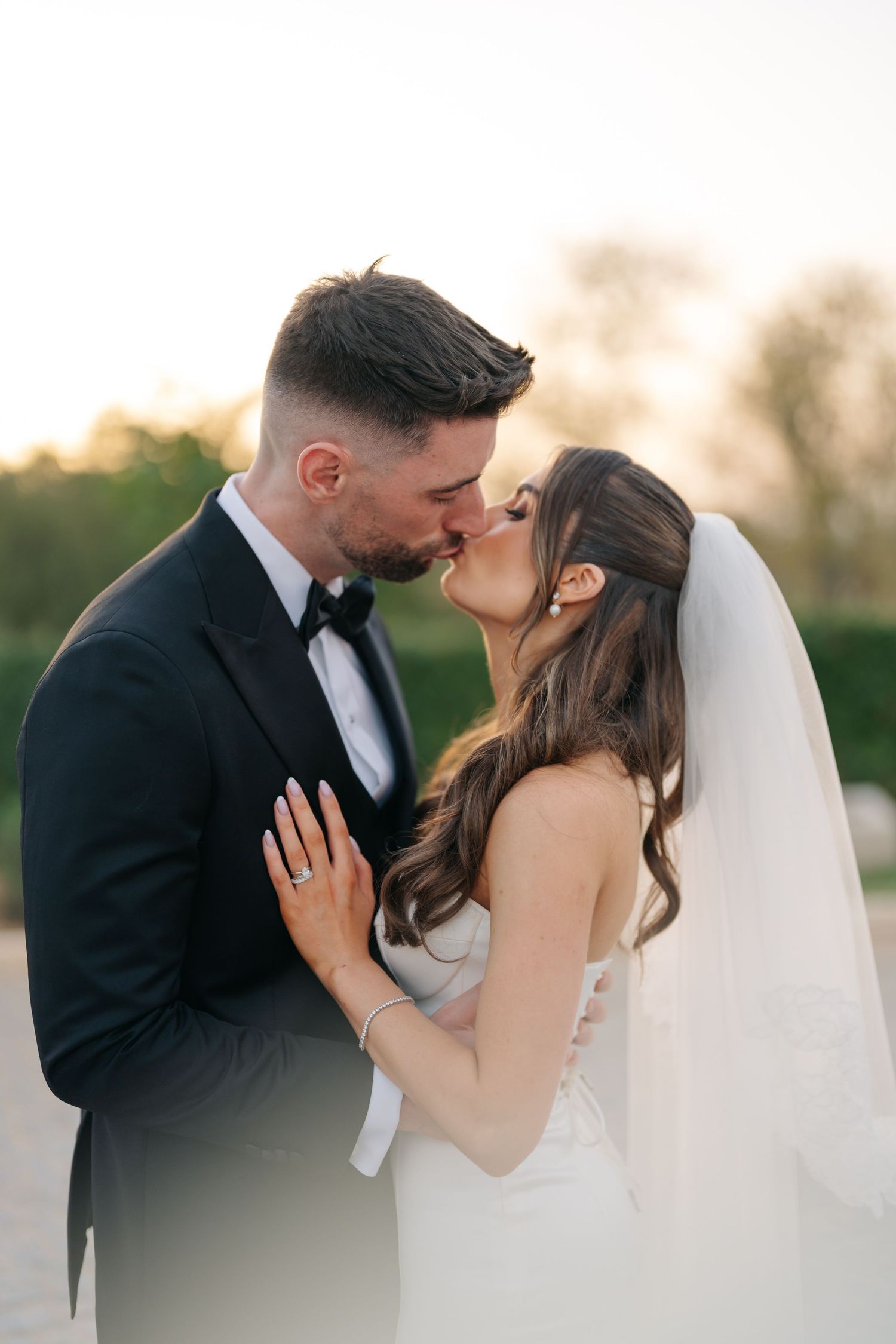 A romantic wedding portrait of a couple sharing an intimate moment at sunset.