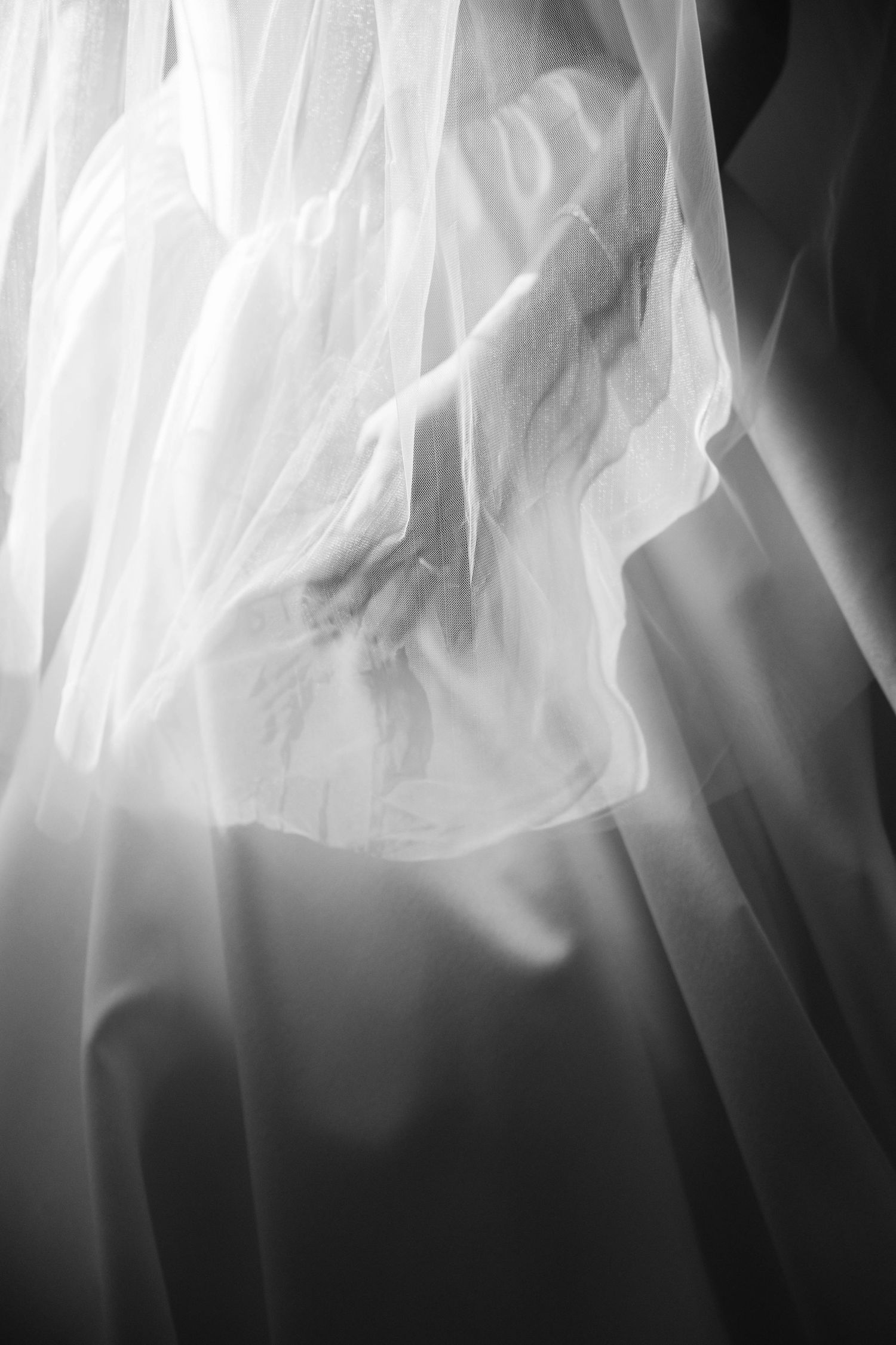 Abstract black and white photograph showing ethereal flowing fabric or smoke creating dramatic light and shadow patterns.