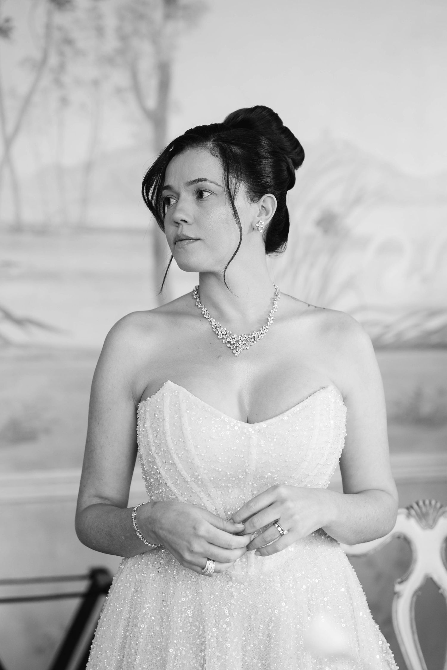 A series of black and white photos showing a bride in a strapless white wedding dress posing elegantly in different angles.