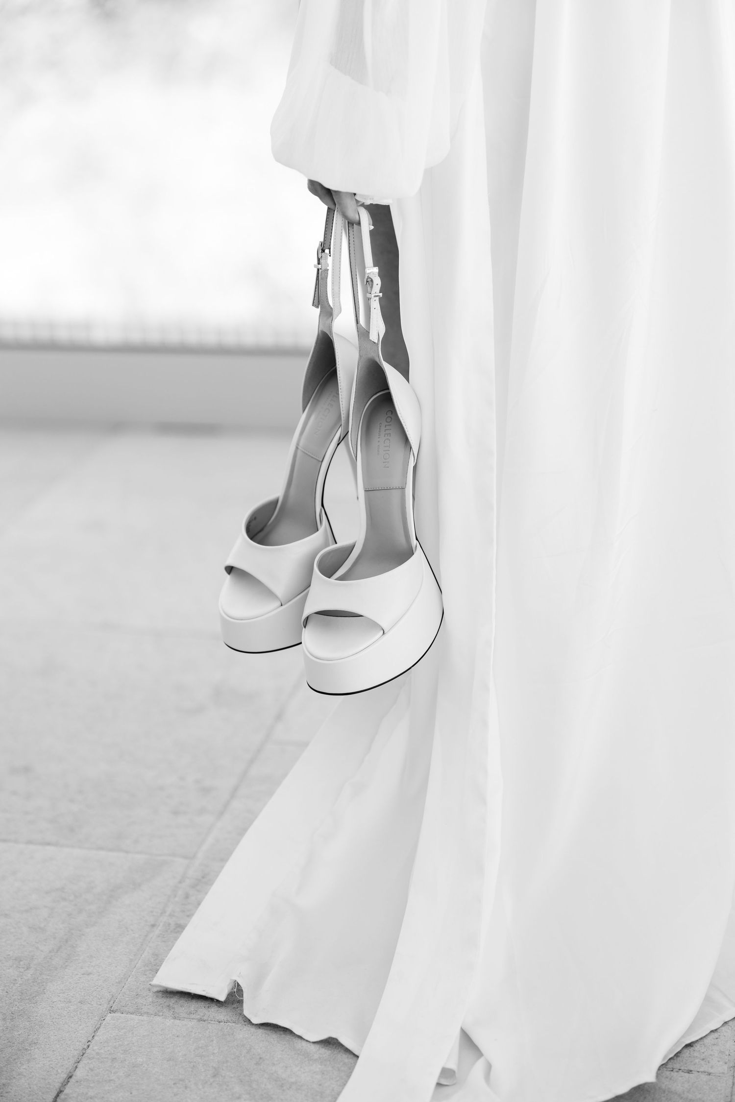White platform bridal shoes placed beside flowing wedding dress hem.