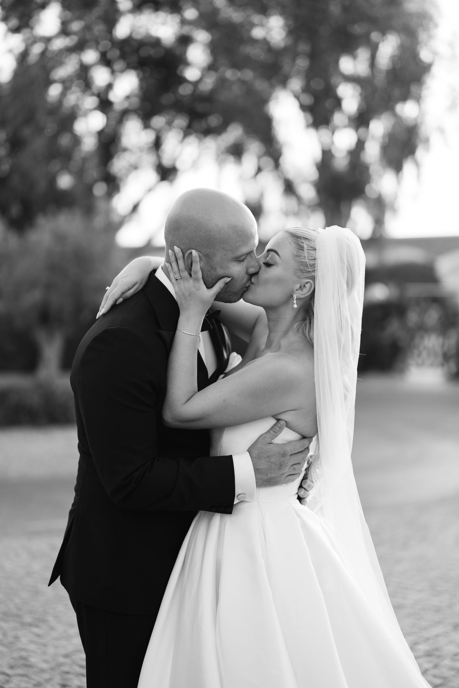 Black and white romantic wedding portrait showing tender moment between newlyweds.