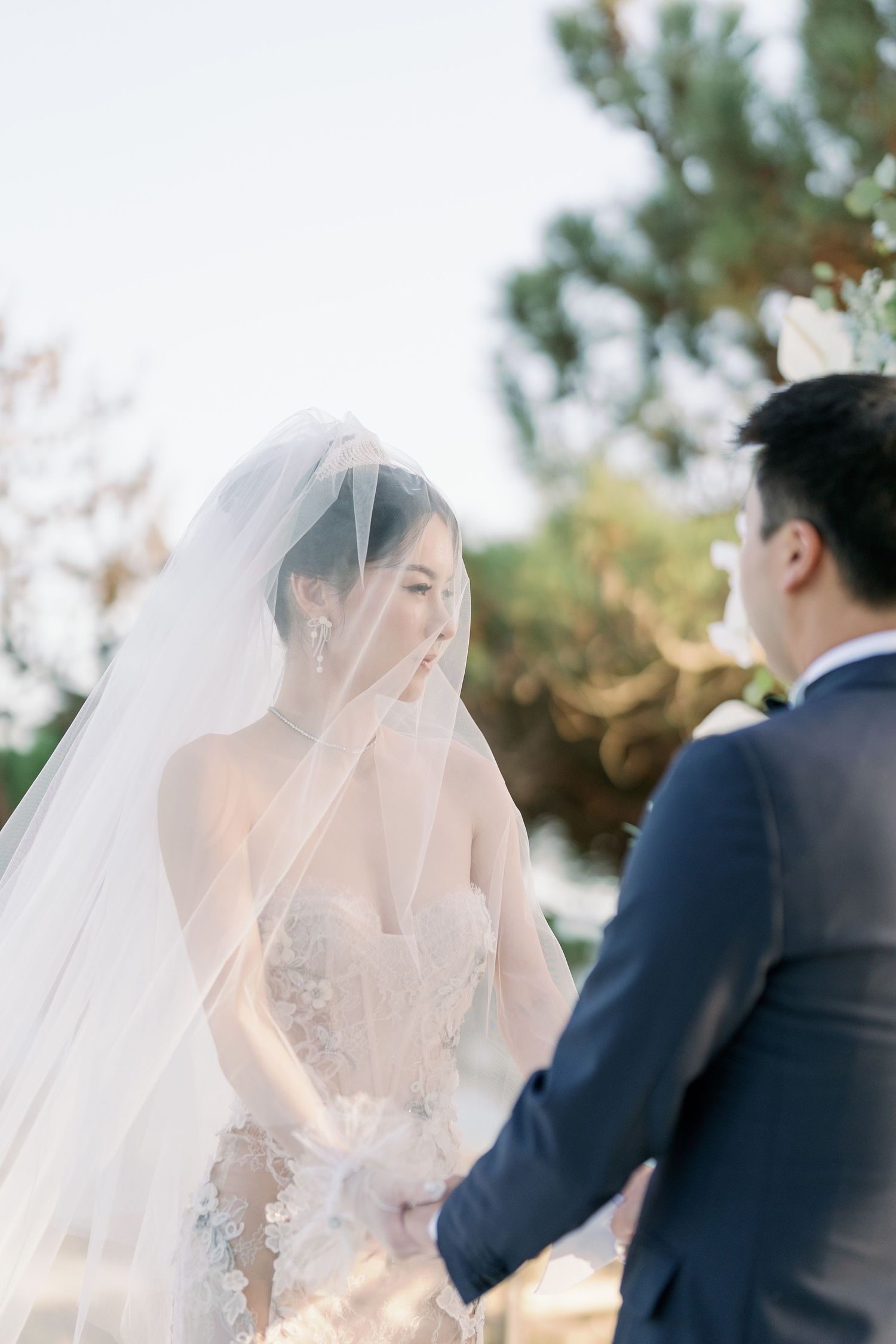 Romantic wedding ceremony moment captured in soft natural light outdoors.