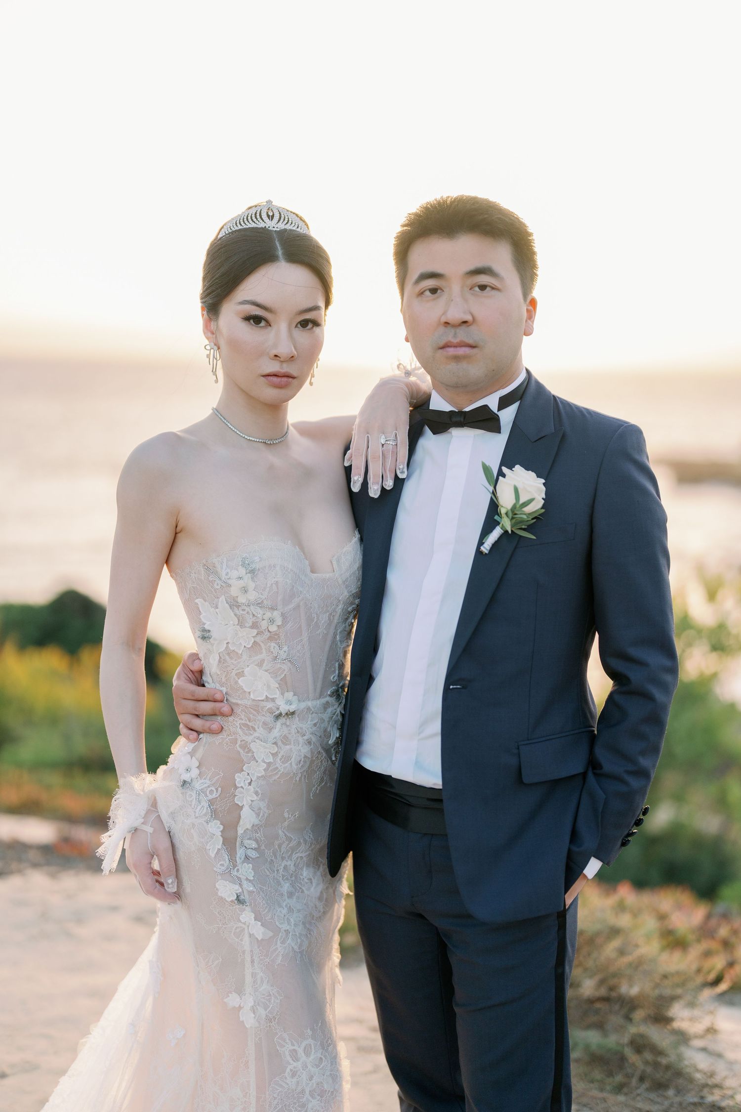 Wedding couple poses together on scenic outdoor terrace during sunset.