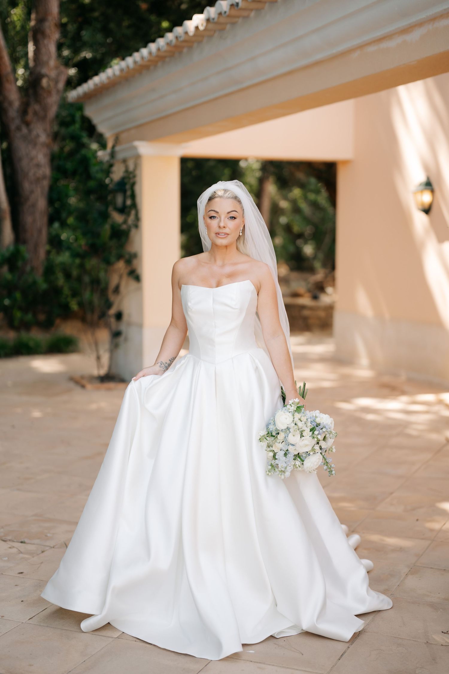 Classic white ballgown wedding dress photographed in outdoor Mediterranean venue.